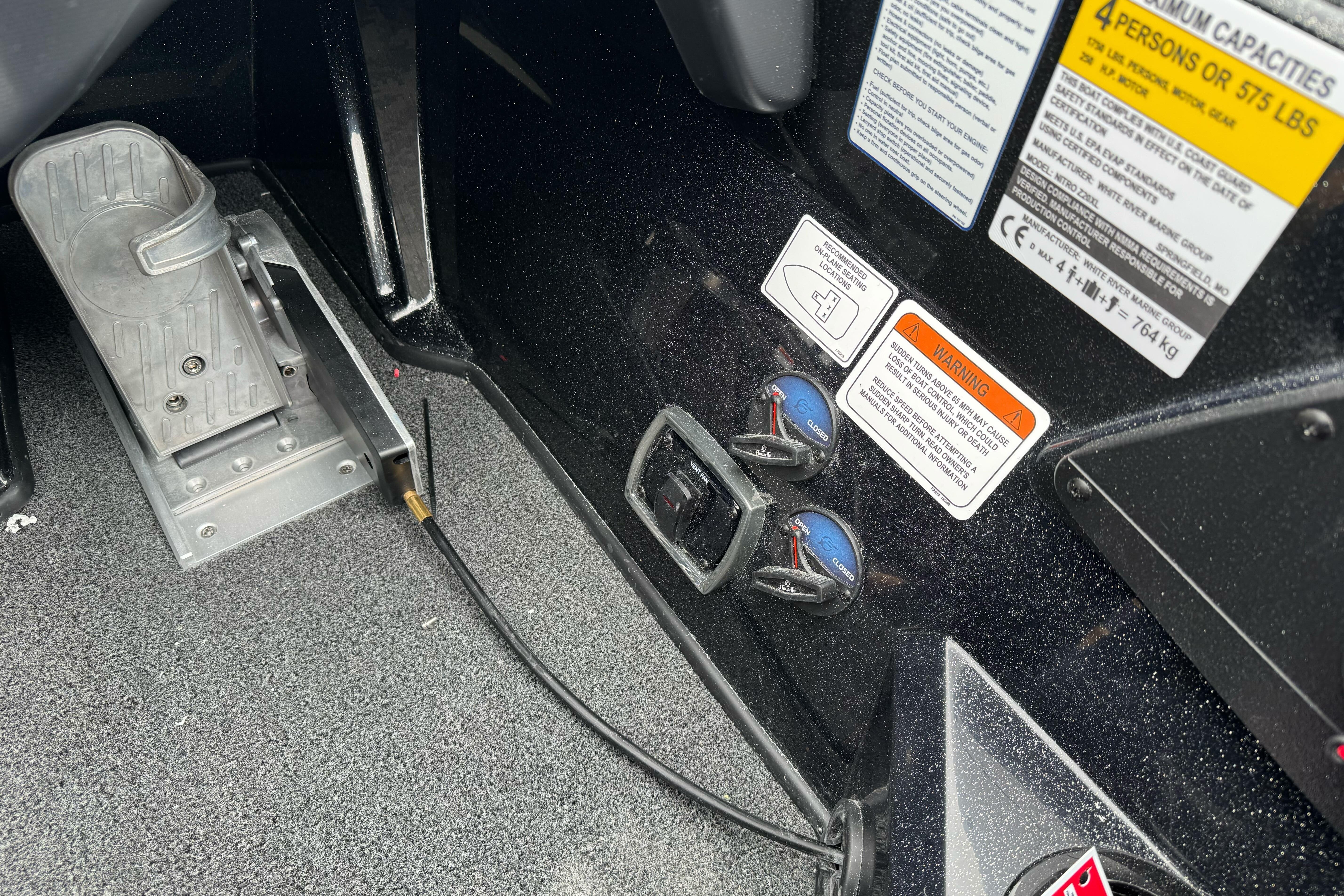Interior view of a 2026 Nitro Z20 XL Pro boat, showing foot pedal and warning labels.