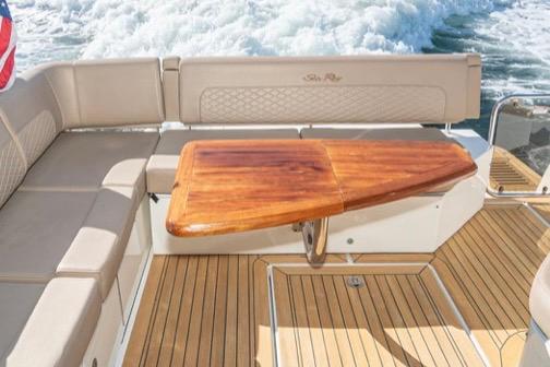 2017 Sea Ray 460 Sundancer yacht with elegant wooden table and cushioned seating.