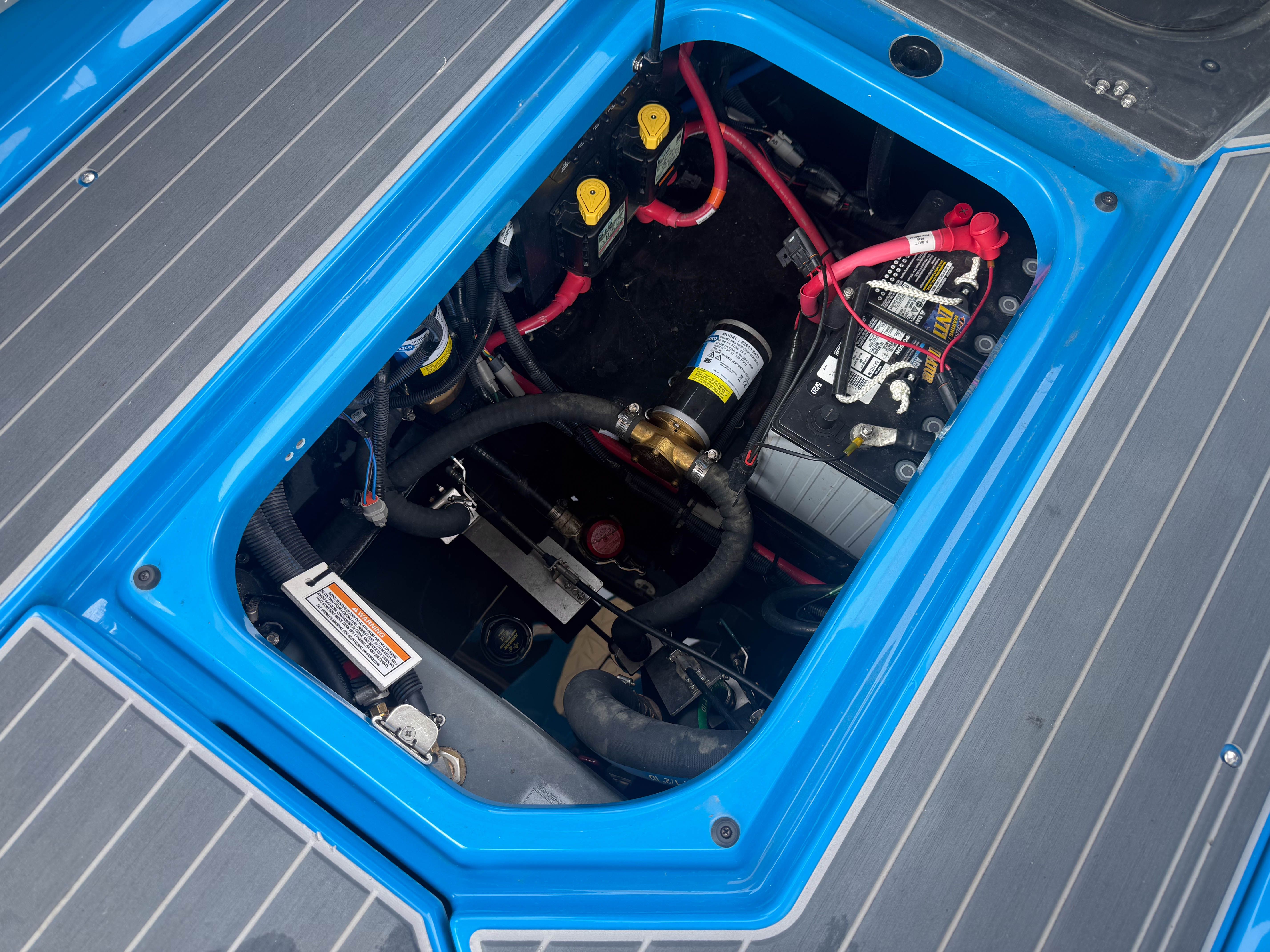 An open compartment of a boat showing cables and batteries.