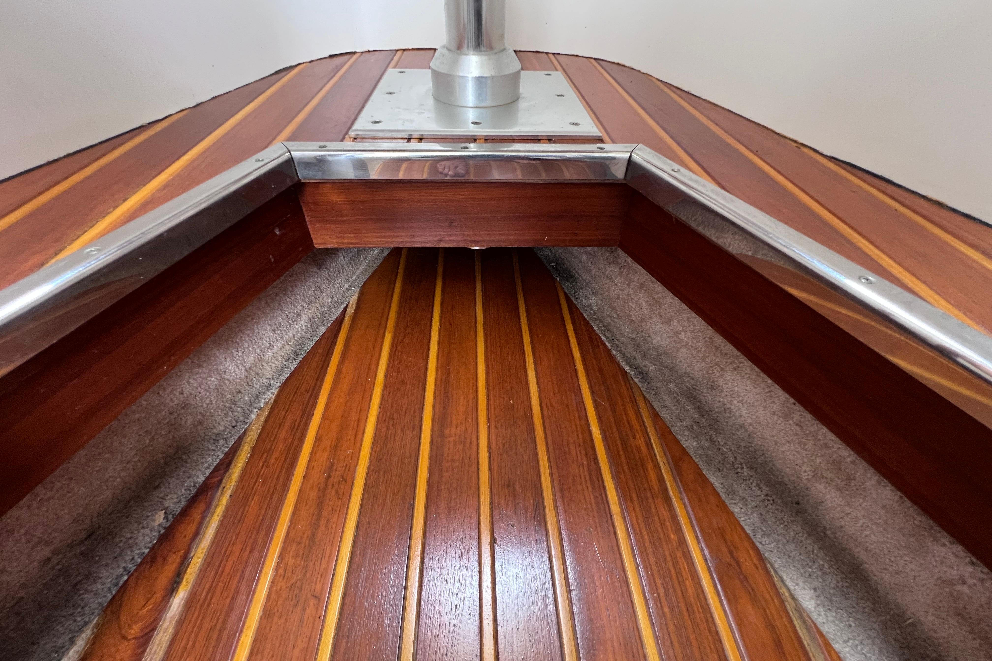 Interior view of 2005 Pursuit 3070 Offshore boat with polished wood flooring and metal accents.