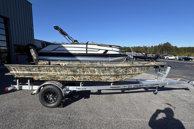 2026 War Eagle 648LDV boat on trailer, camouflage design, parked outdoors.