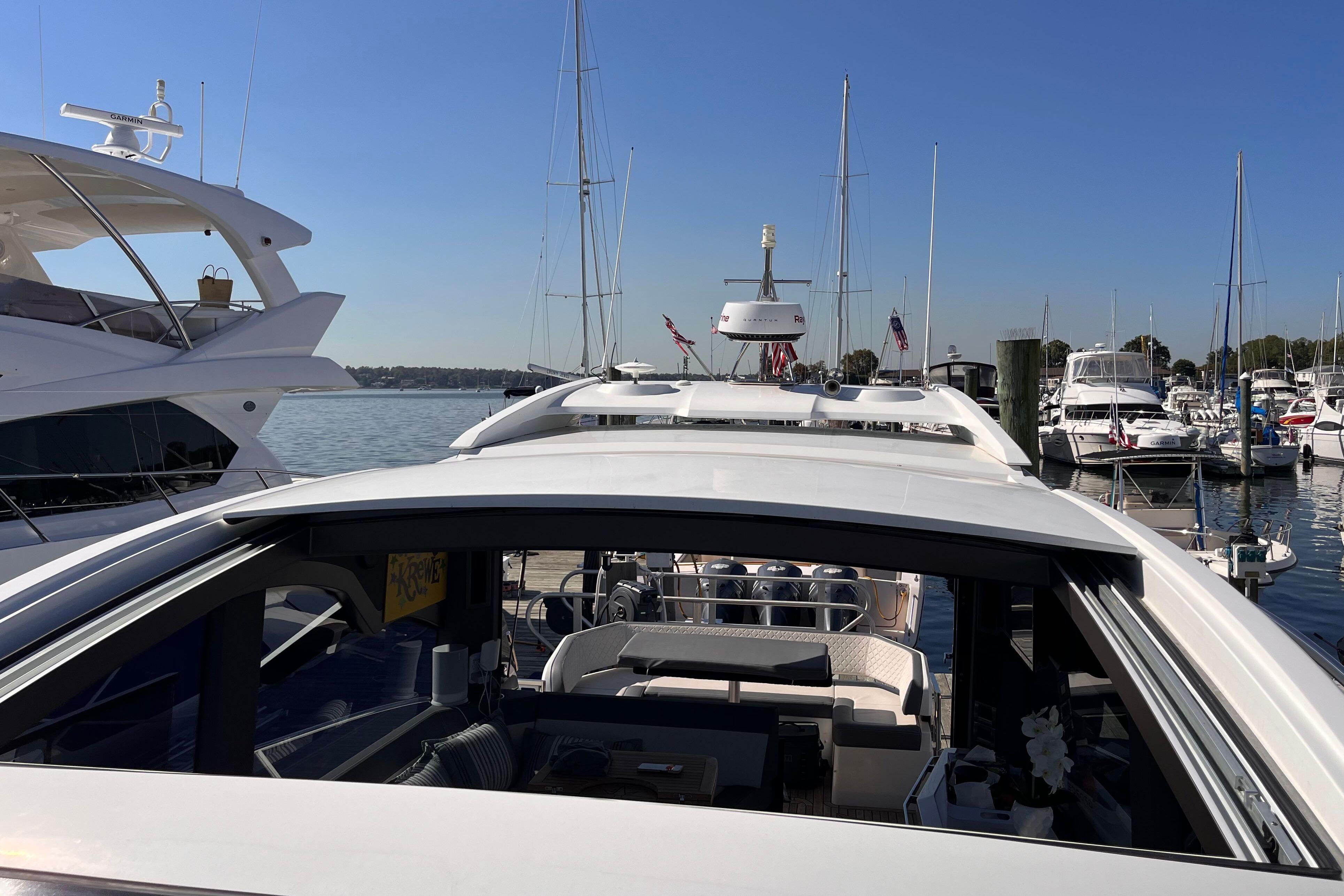 2024 Galeon 425 HTS yacht docked at marina, surrounded by other boats under clear blue sky.