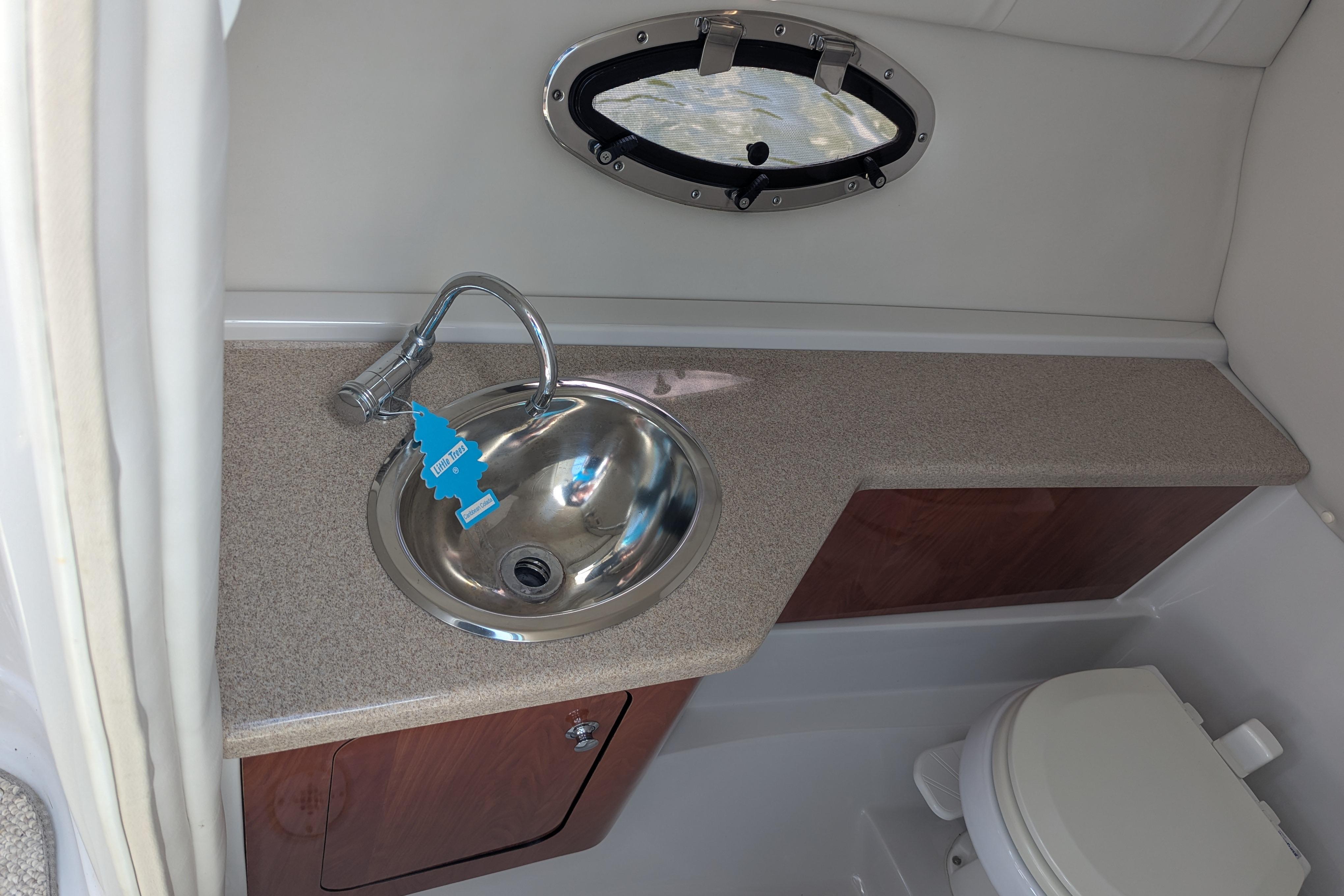 2008 Crownline 300 LS boat bathroom with sink, countertop, and toilet.