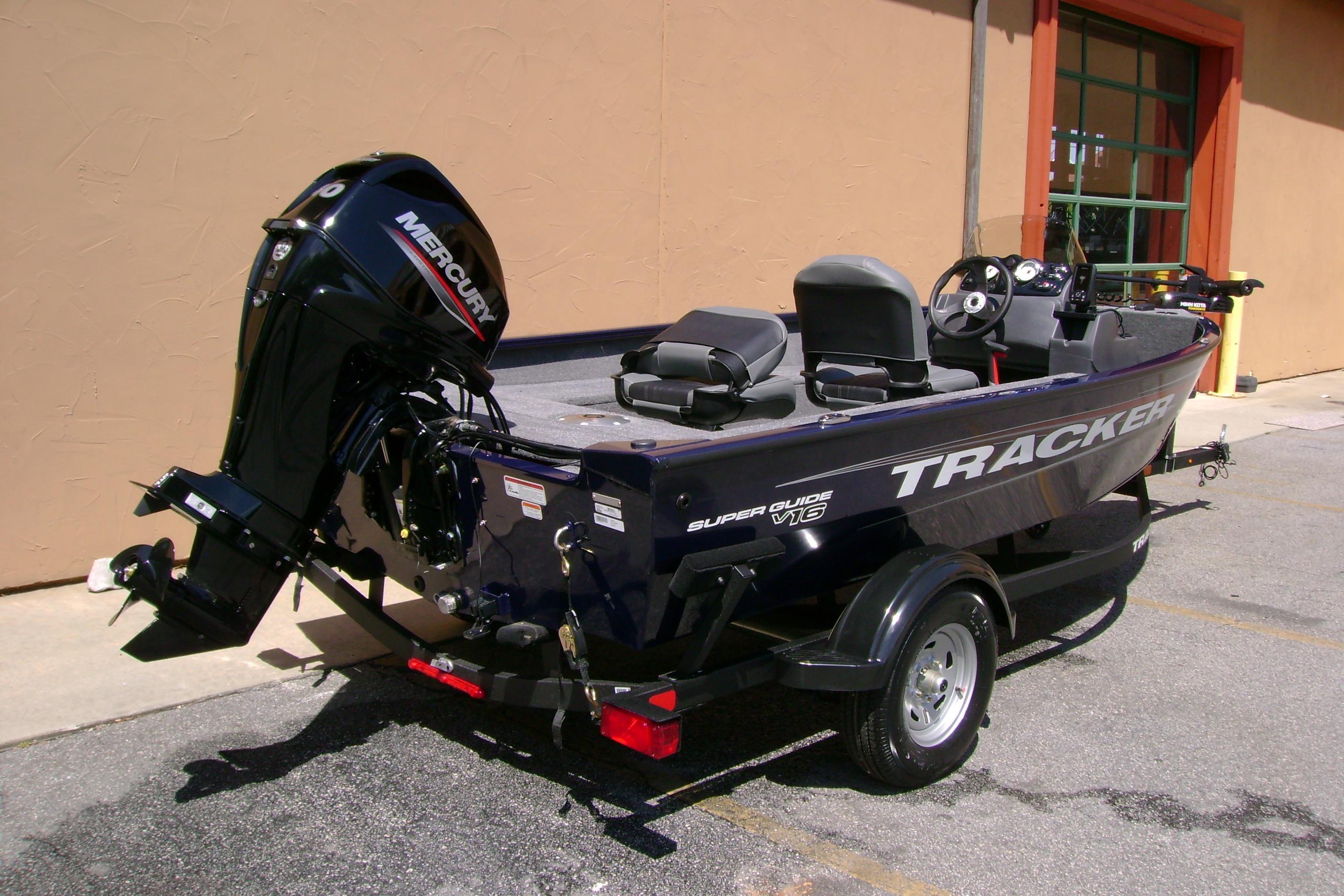 2026 Tracker Super Guide V-16 SC boat with Mercury outboard motor, parked outdoors.