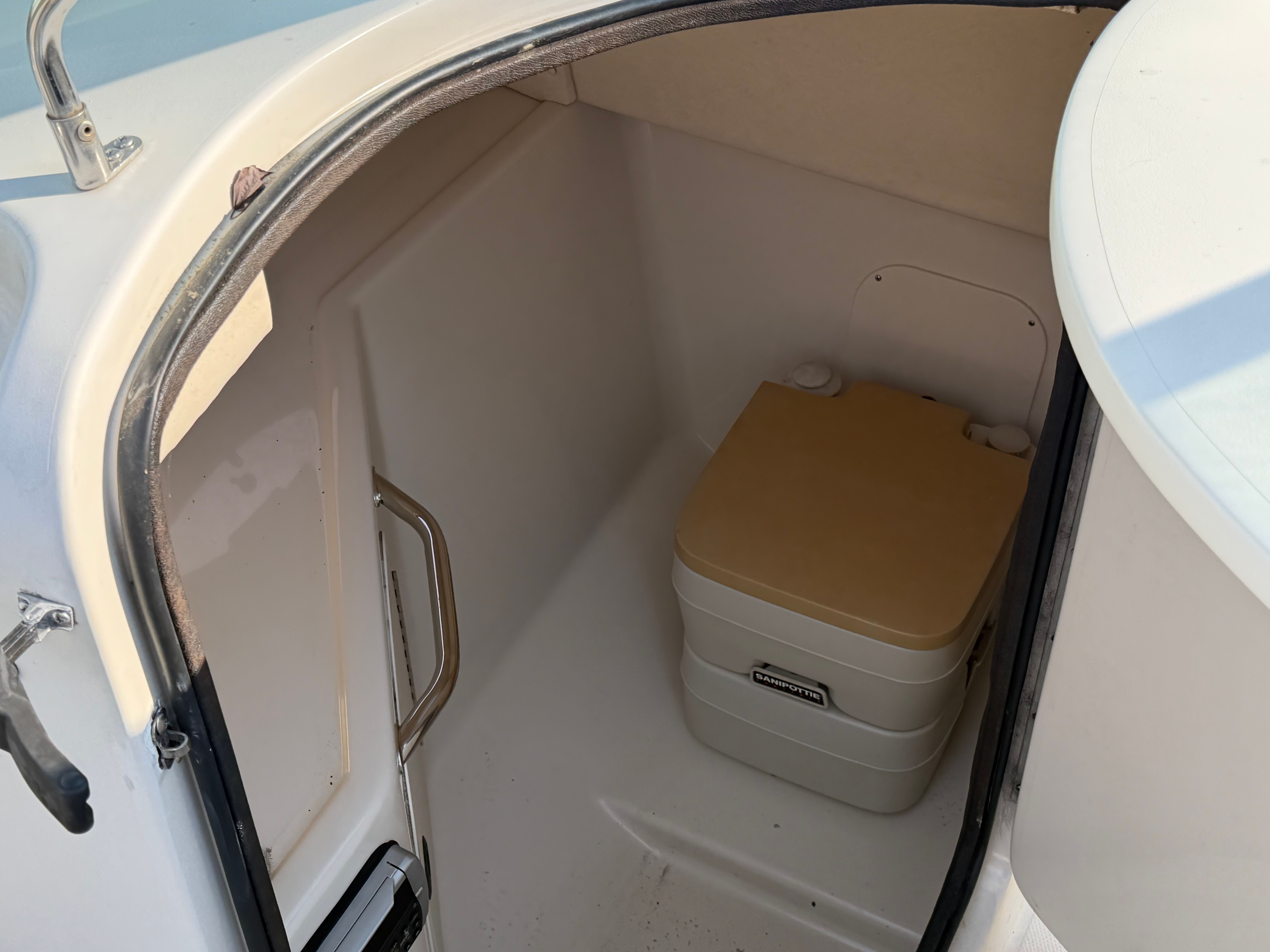 Interior of 2004 Sea Ray 270 Sundeck with portable toilet.