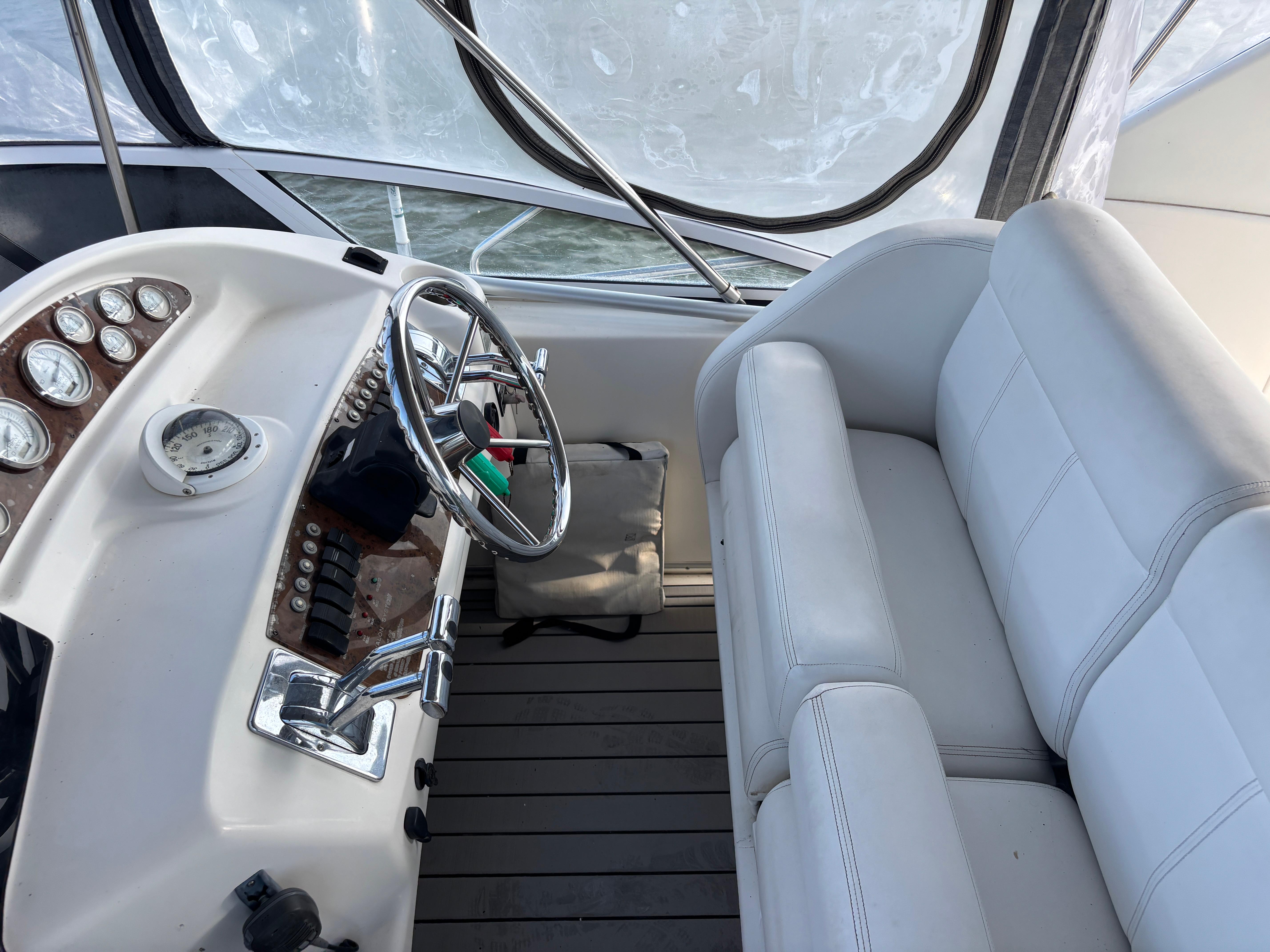 2001 Silverton 410 Sport Bridge helm with steering wheel and white seating.