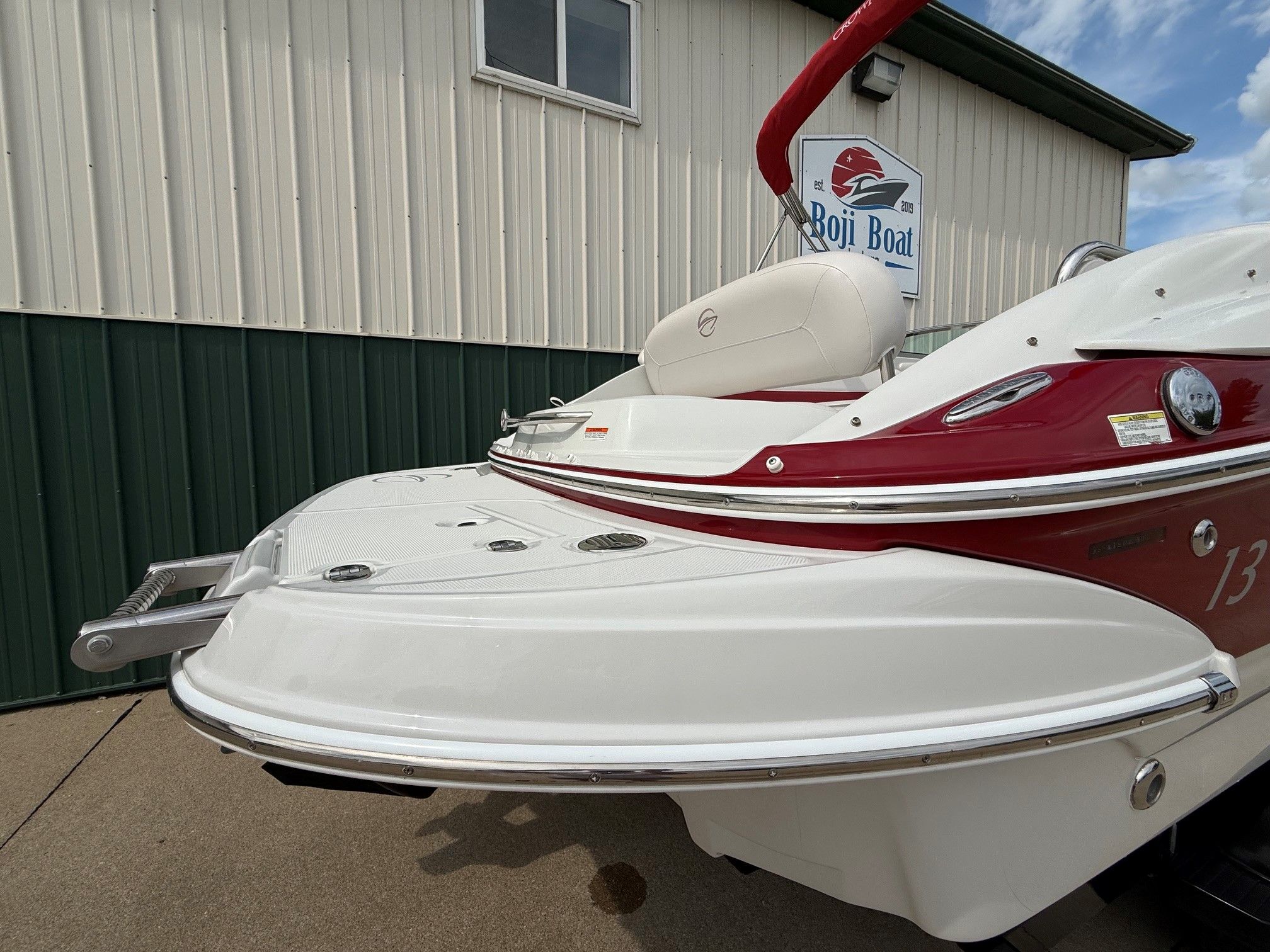 The image shows the stern of a 2012 Crownline 252 EX boat with red accents.