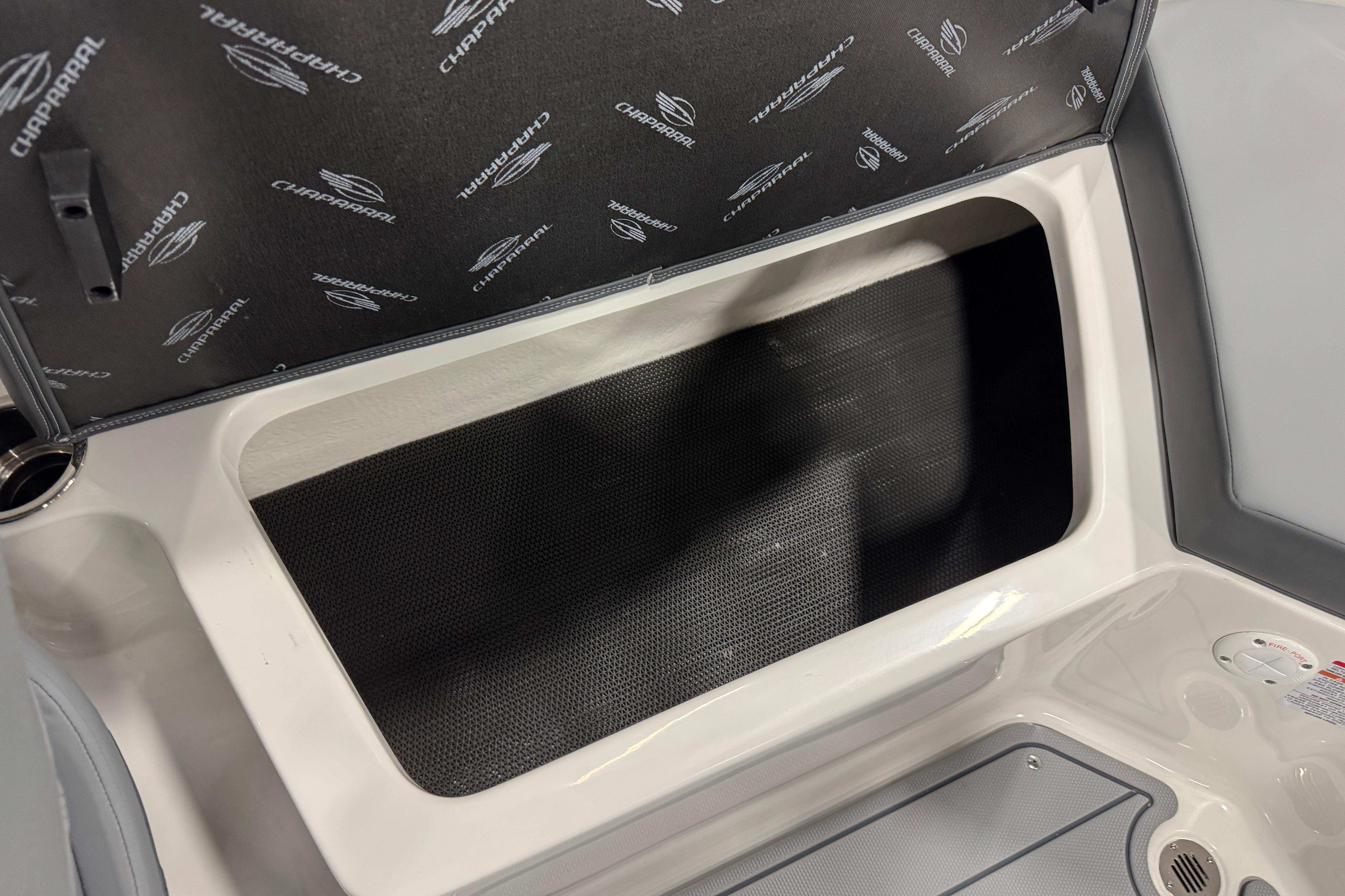 Storage compartment in 2026 Chaparral 23 SSi boat, featuring branded interior lining.