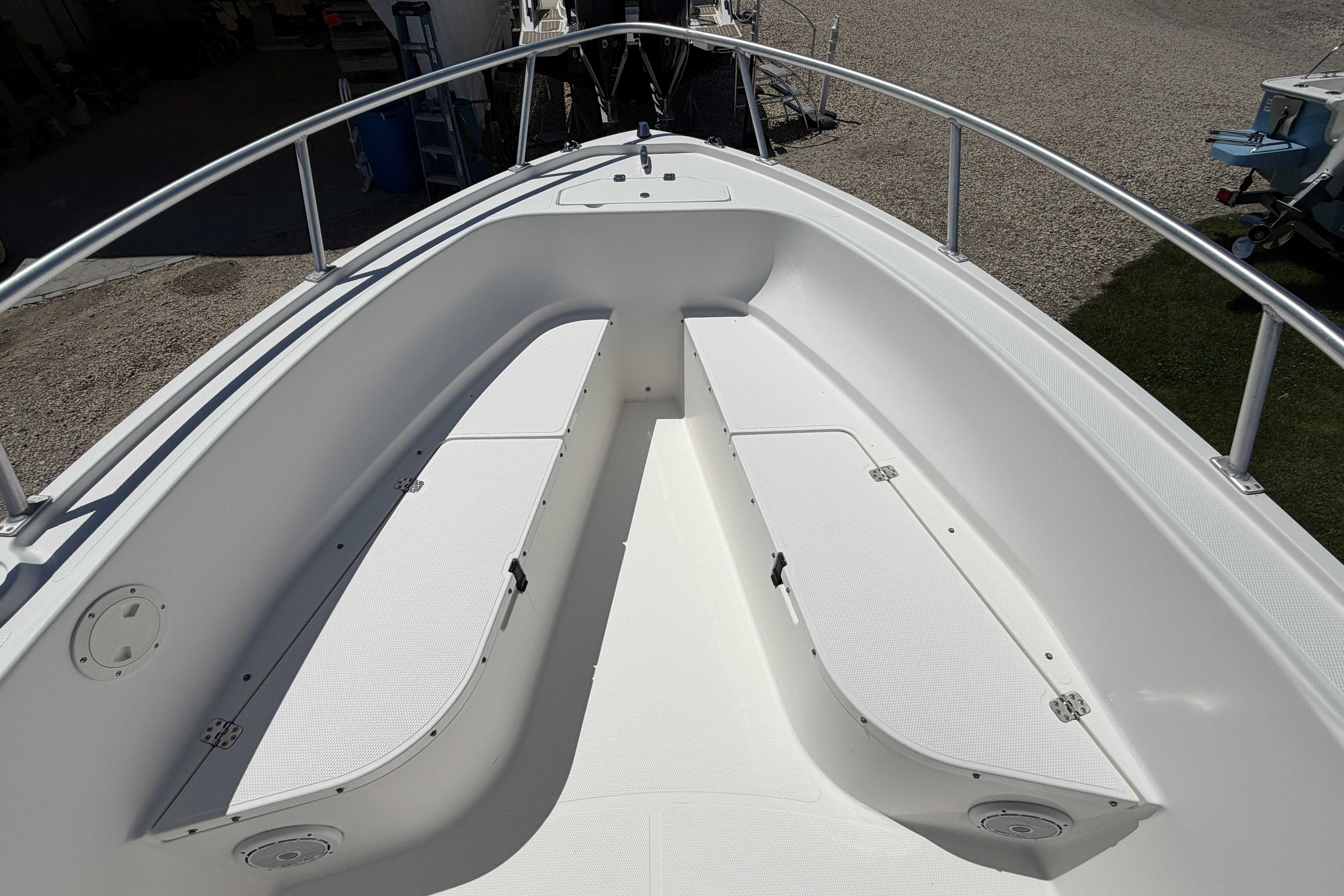 2006 Mako 212 Center Console boat interior with white seating and storage compartments.