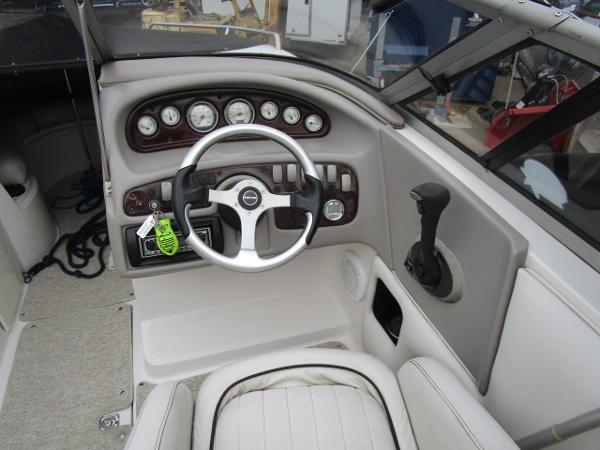 2004 Ebbtide 22 Mystique boat dashboard with steering wheel and control panel.