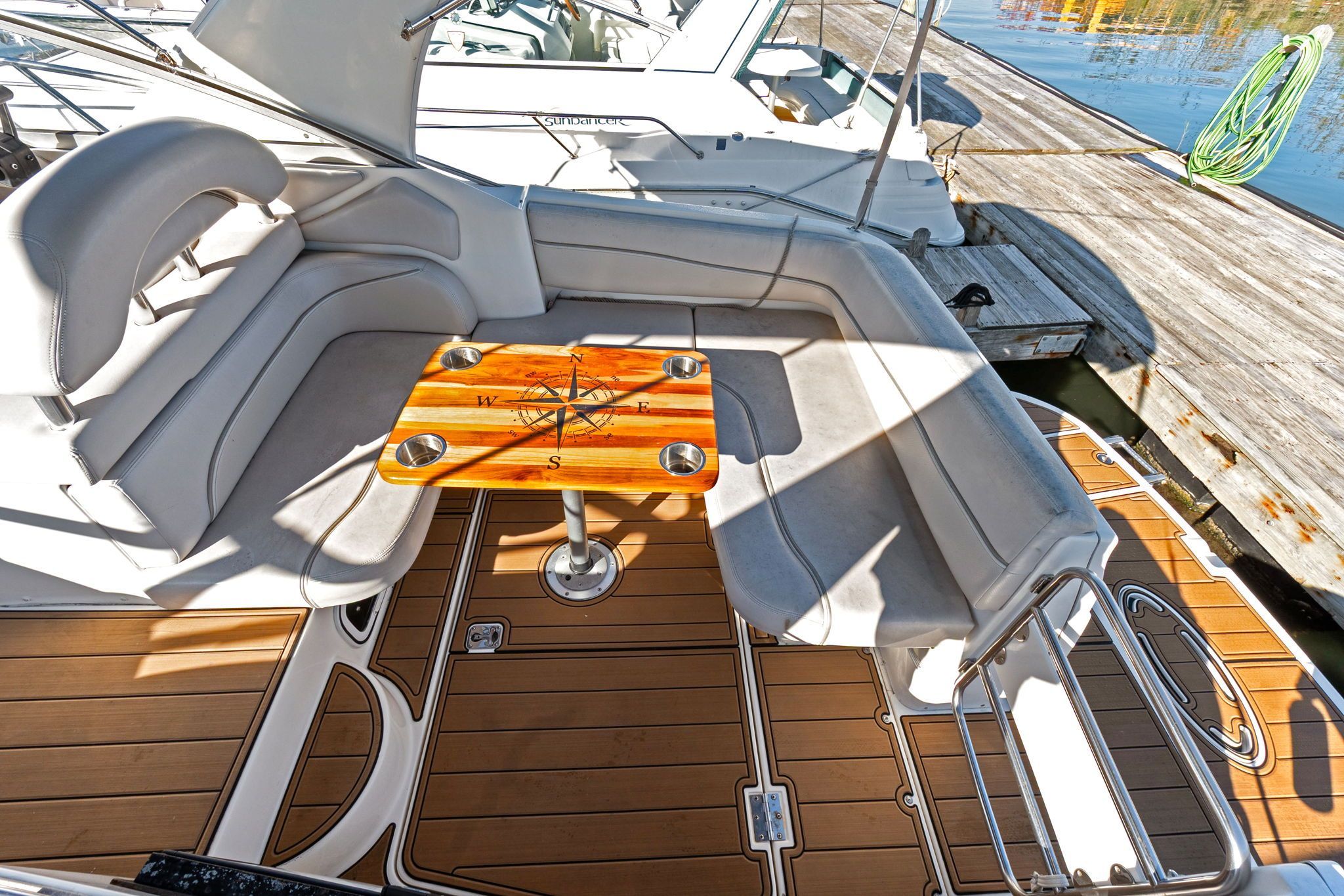 The image shows the cockpit of a 2007 Larson Cabrio 330 with gray seating and a wooden table.