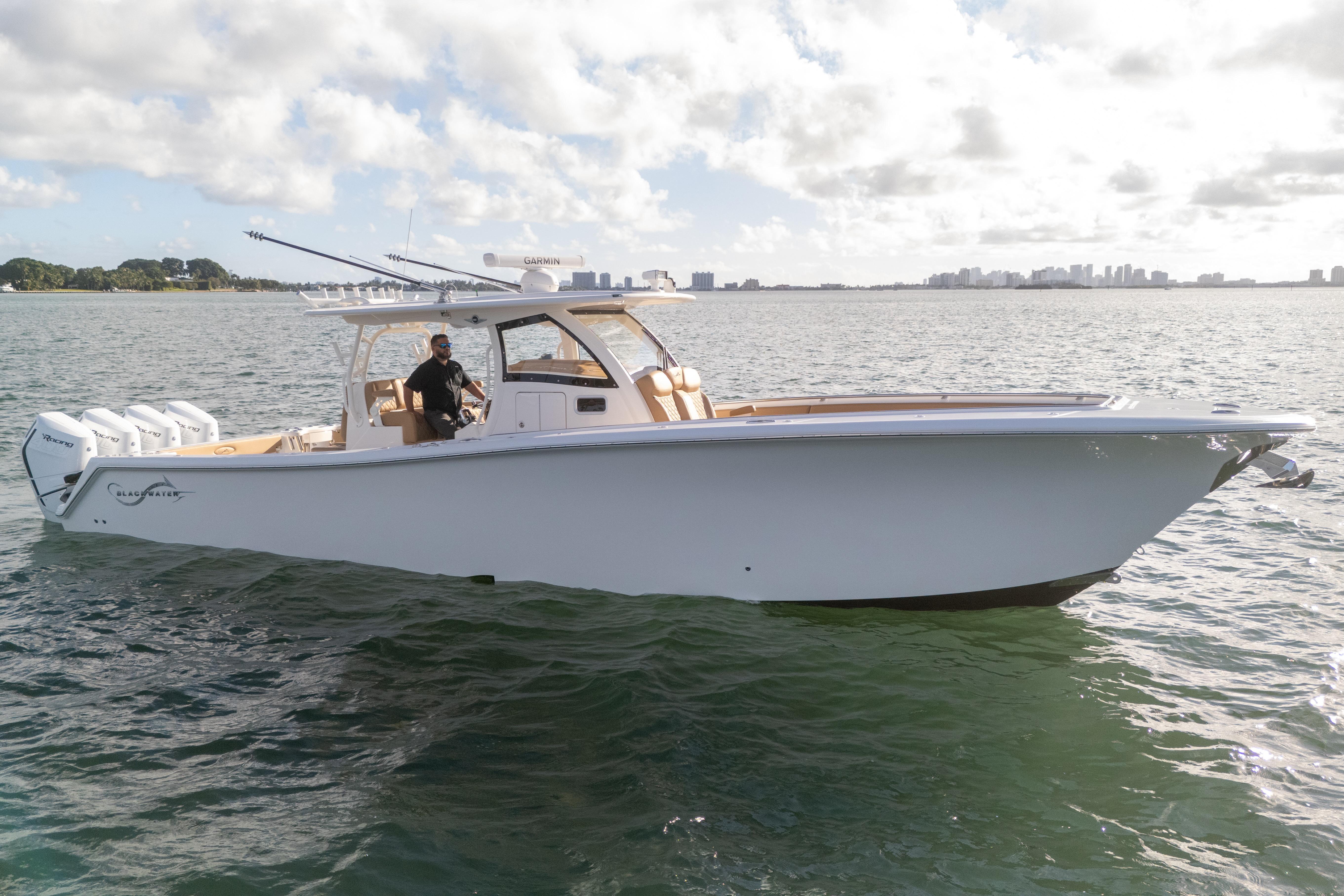2026 Blackwater 41 Performance Fish boat on water, clear sky, city skyline in background.