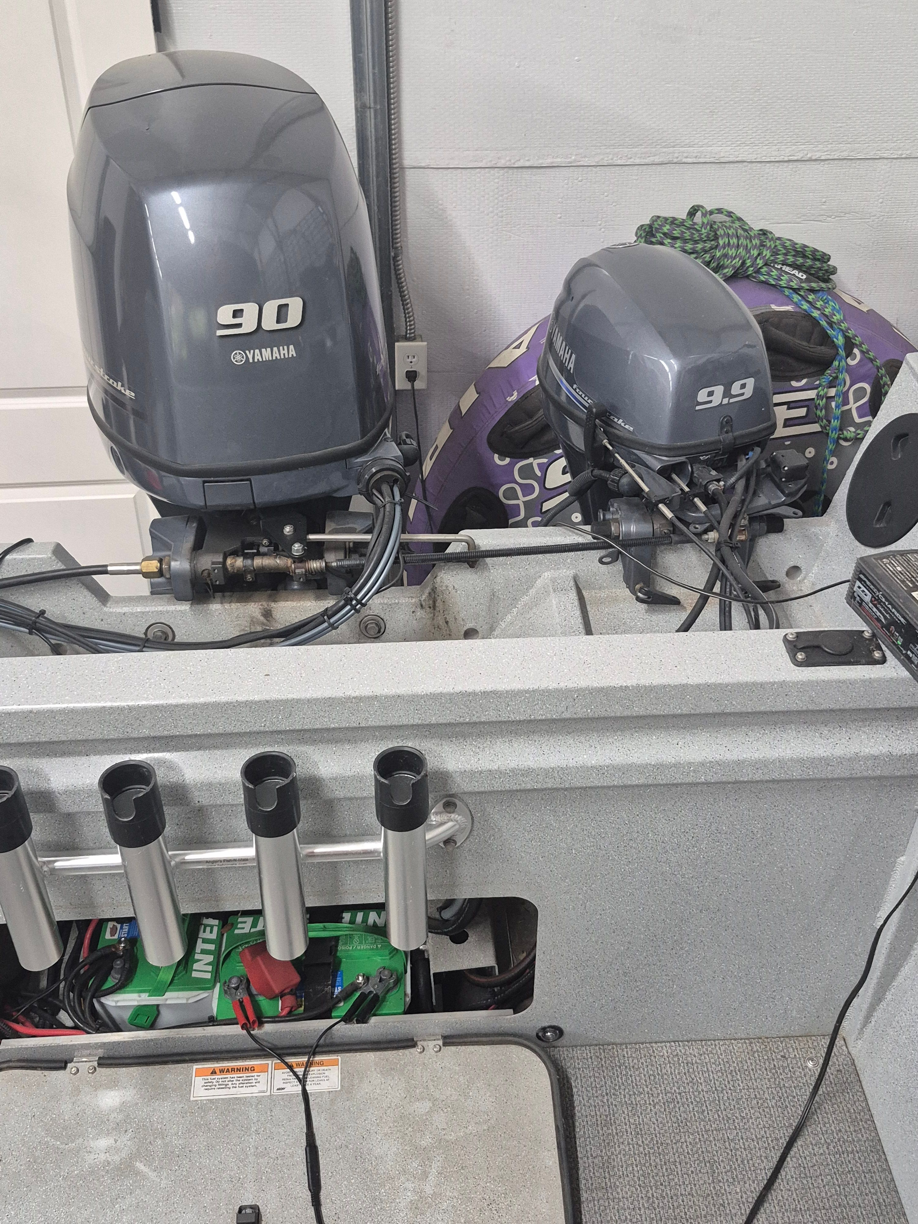 Two Yamaha outboard motors mounted on a boat, surrounded by fishing rod holders and equipment.