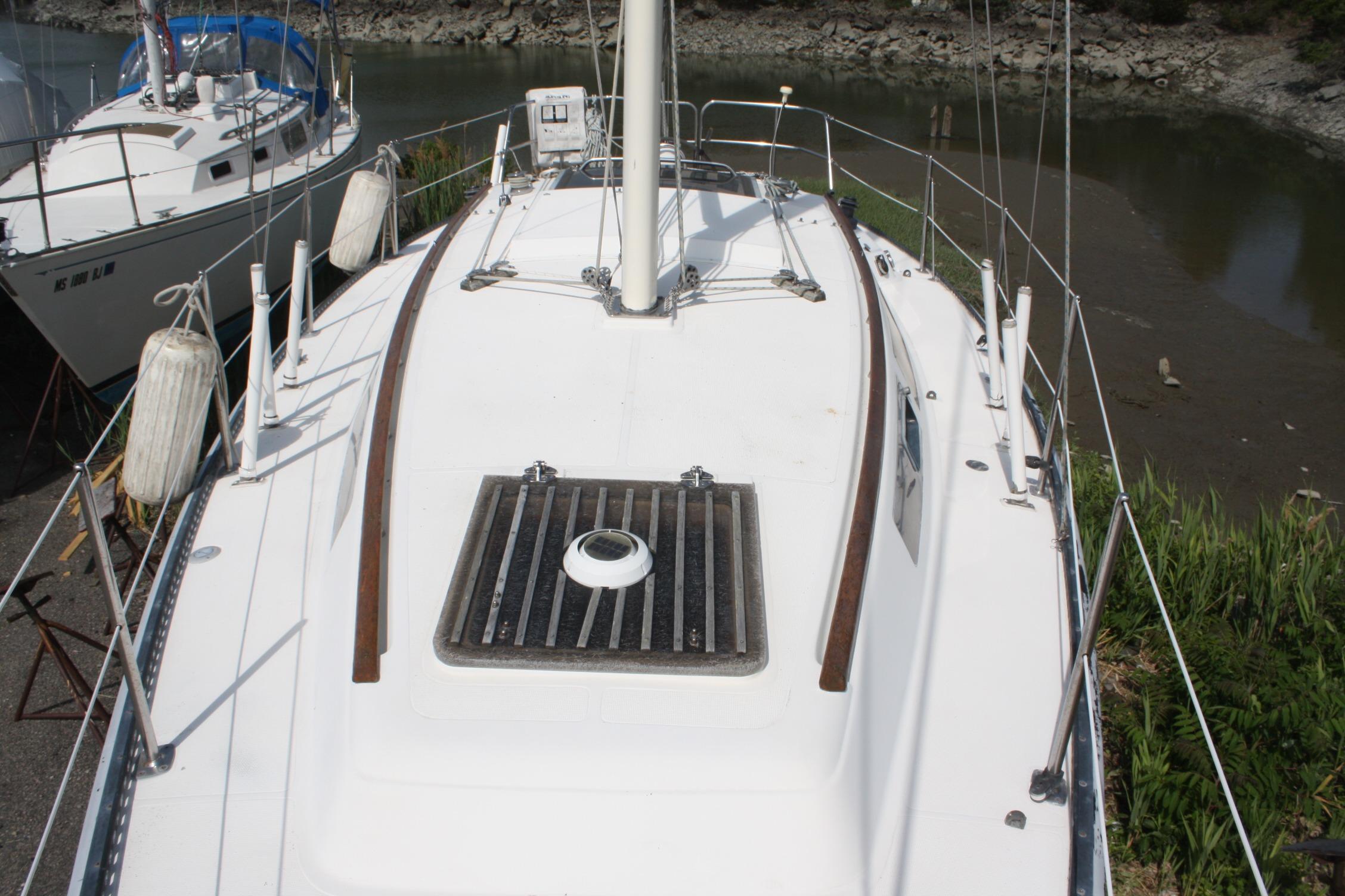 1981 S2 9.2A sailboat deck with railing and hatch, docked near shore.