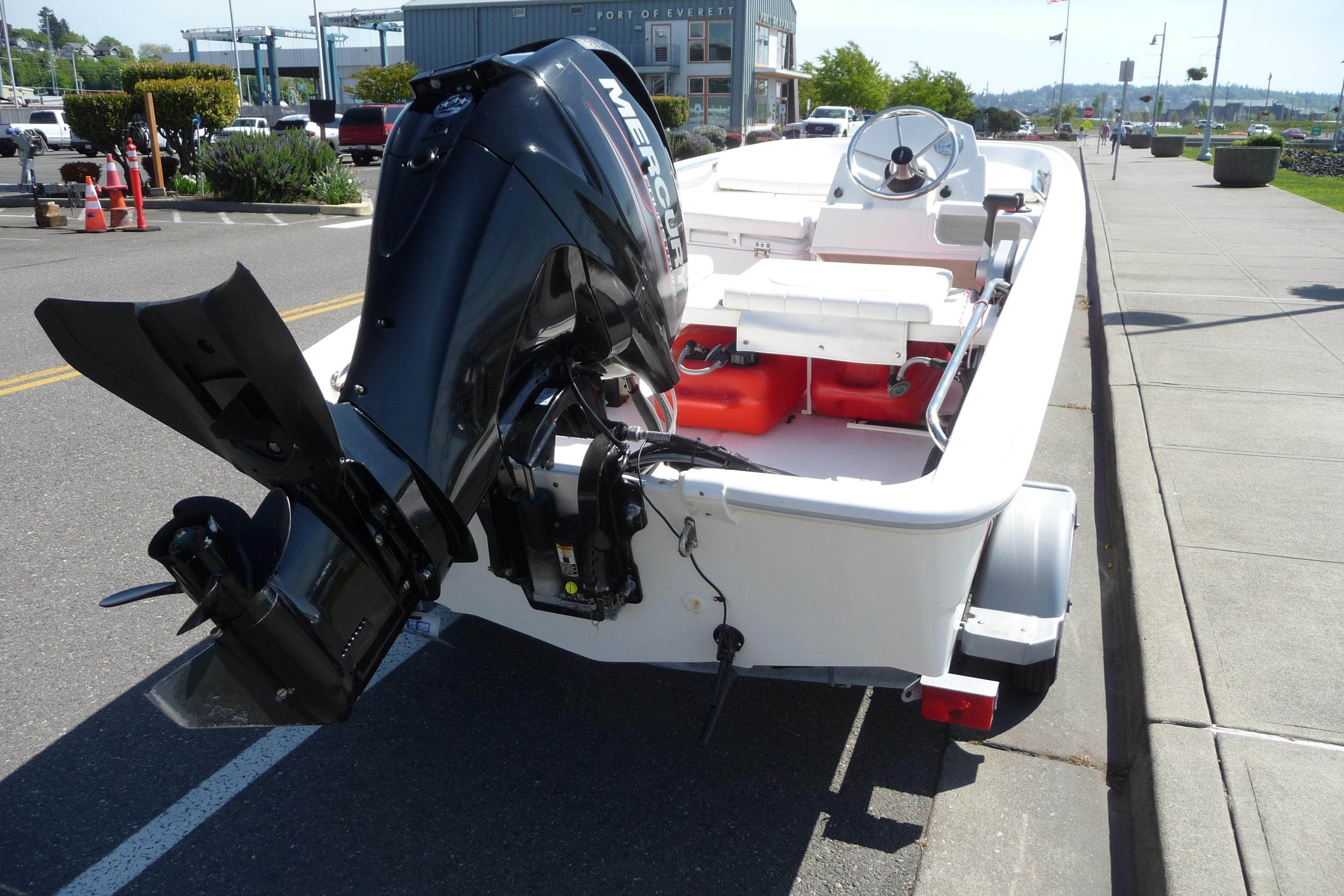 2016 Boston Whaler 130 Super Sport boat with Mercury engine, parked on a street.