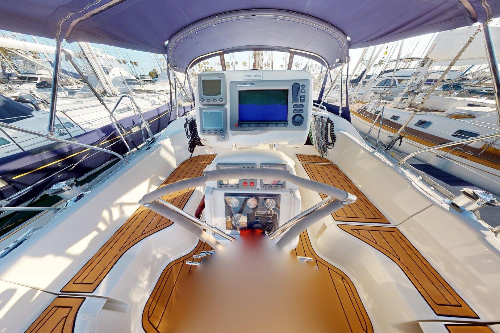 Cockpit of 1997 Hunter Legend 40.5 sailboat with navigation equipment and wooden deck.