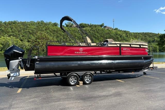 2025 Regency 250 DL3 pontoon boat on trailer, parked in scenic outdoor setting.