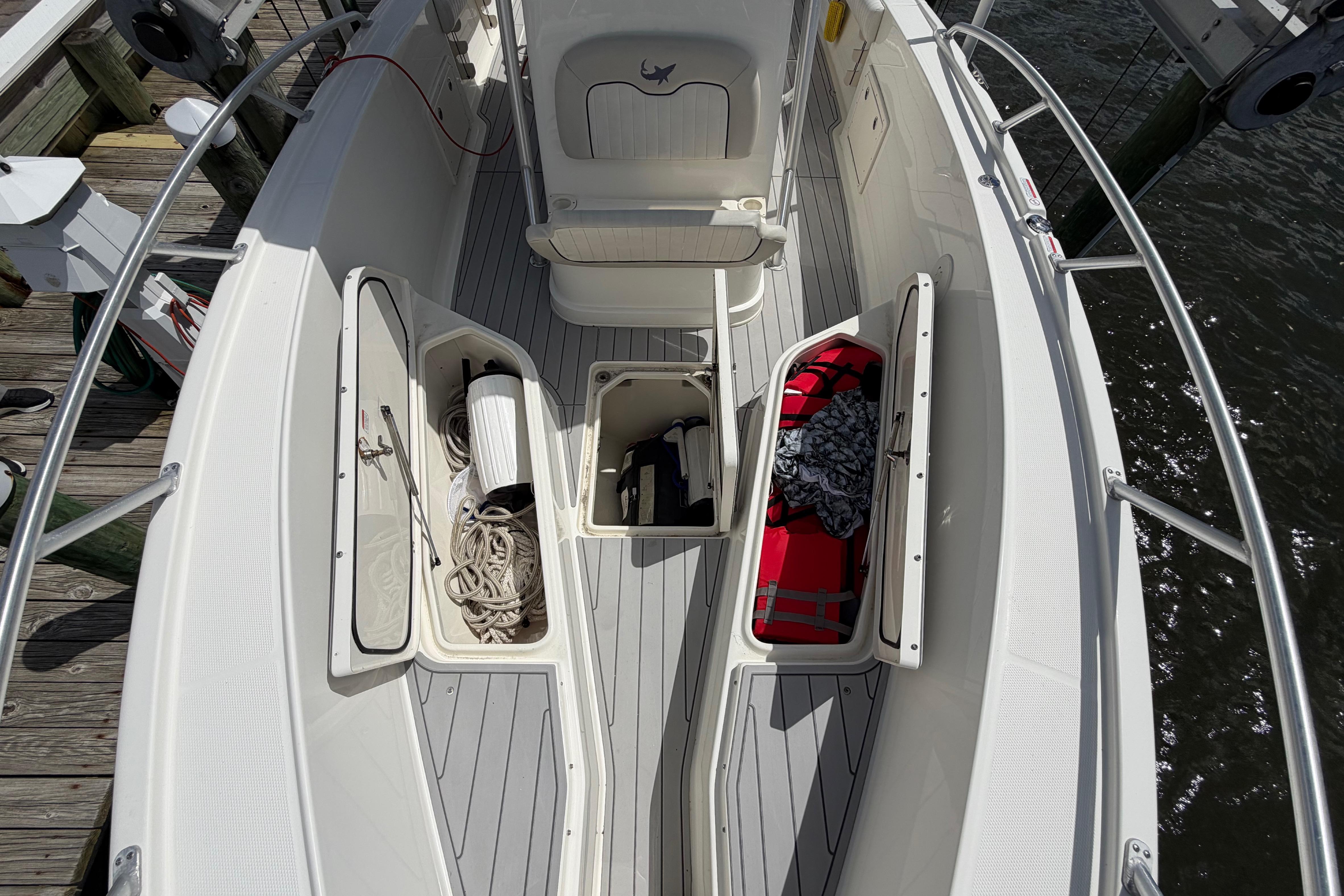 2017 Mako 284 Center Console boat deck with open storage compartments and nautical gear.