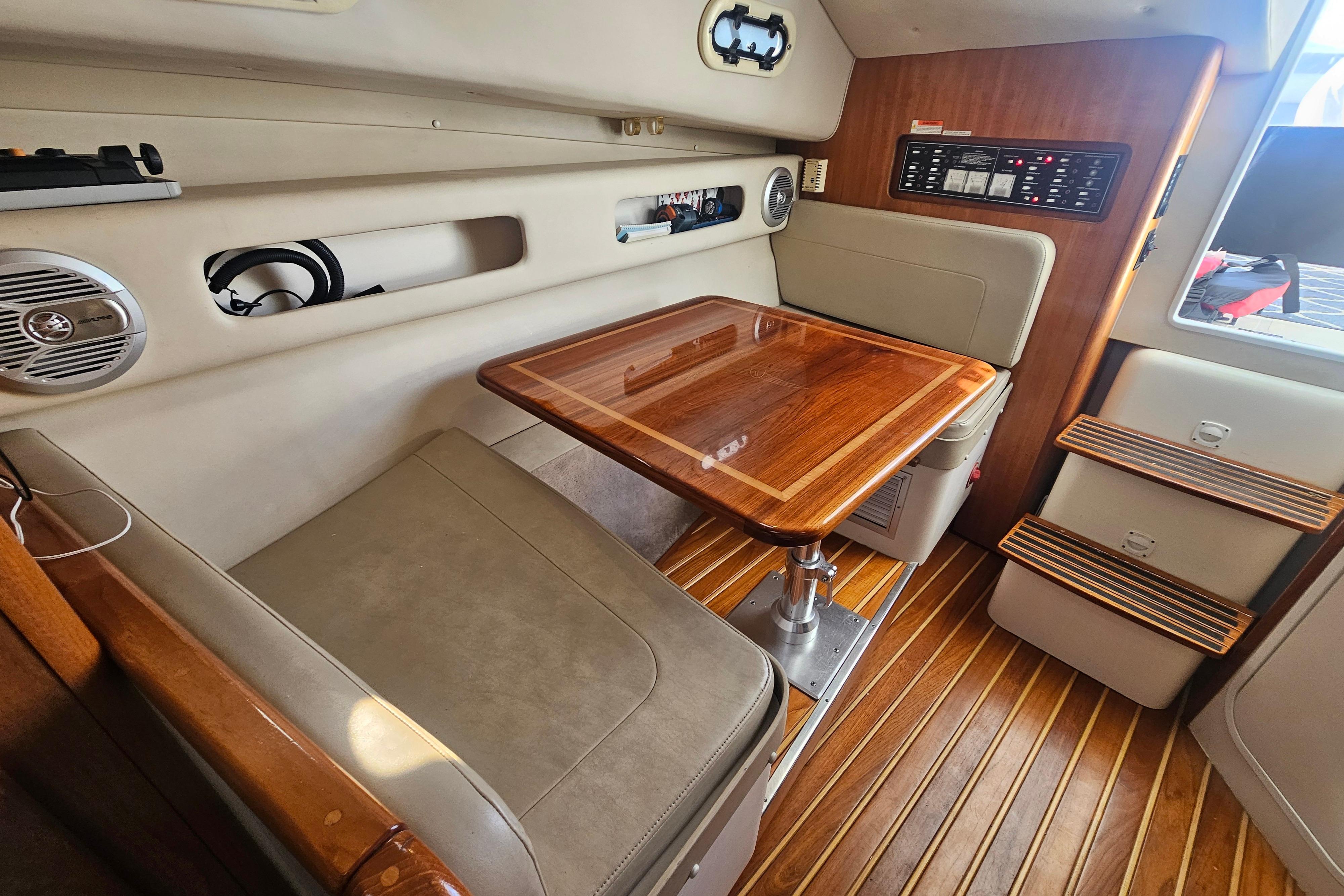 2001 Pursuit 3000 Express cabin interior with wooden table and seating area.