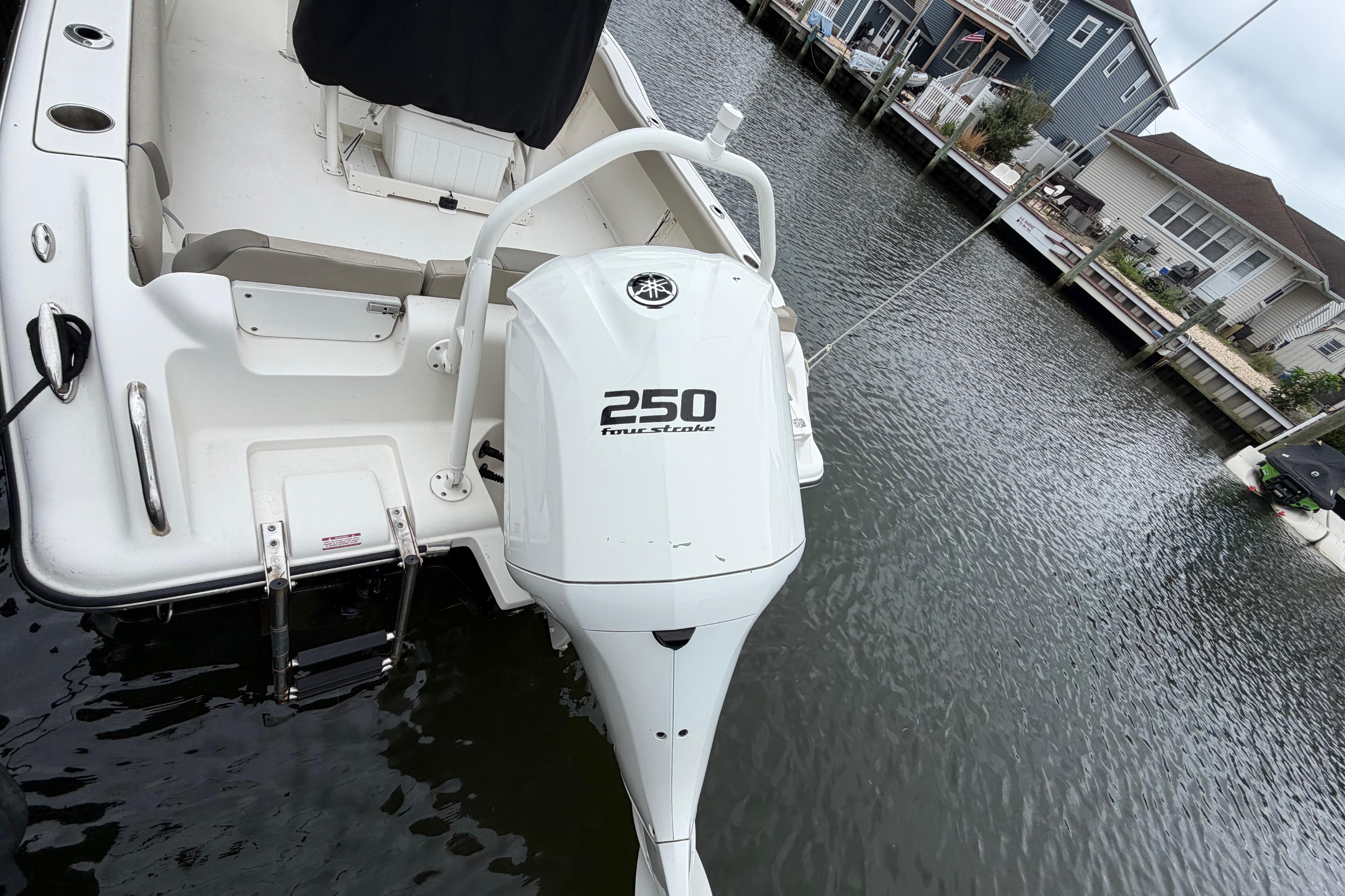 2022 Key West 239 FS boat with Yamaha 250 outboard motor docked by waterfront homes.
