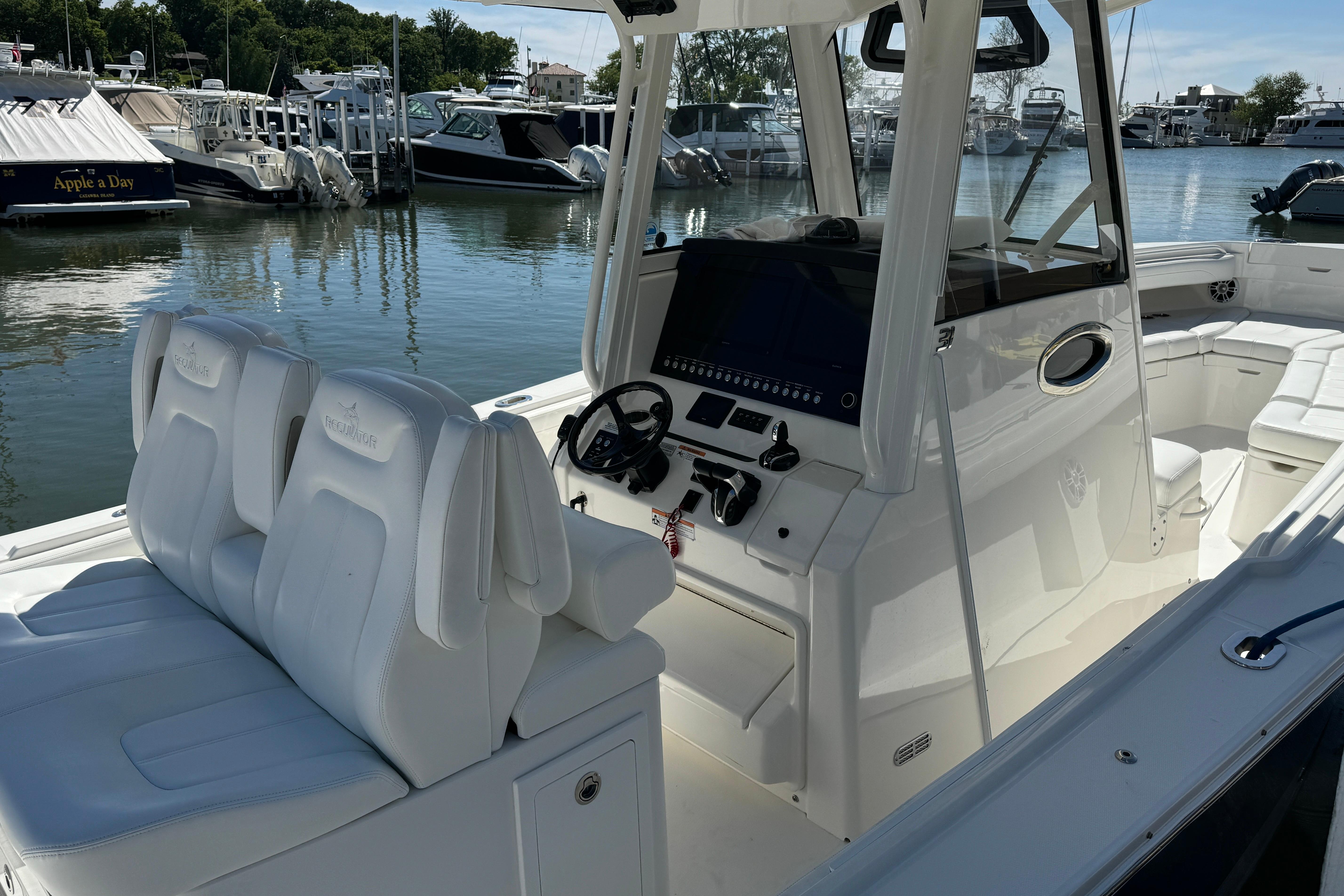 2021 Regulator 31 boat interior with white seating and control panel at marina.