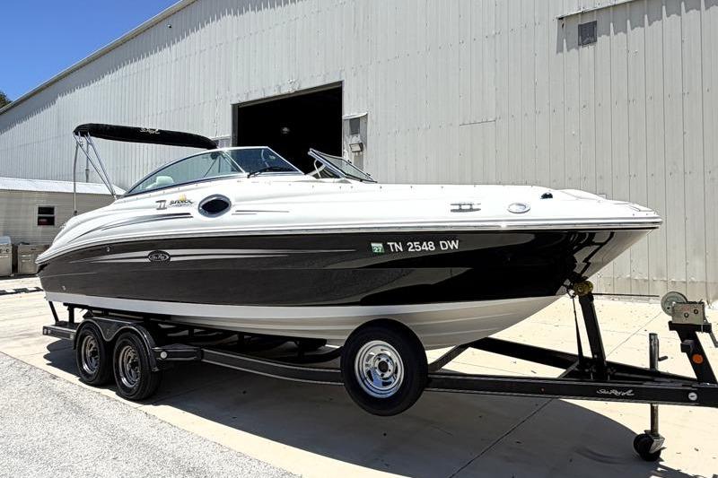 2007 Sea Ray 240 Sundeck boat on trailer outside a large warehouse.