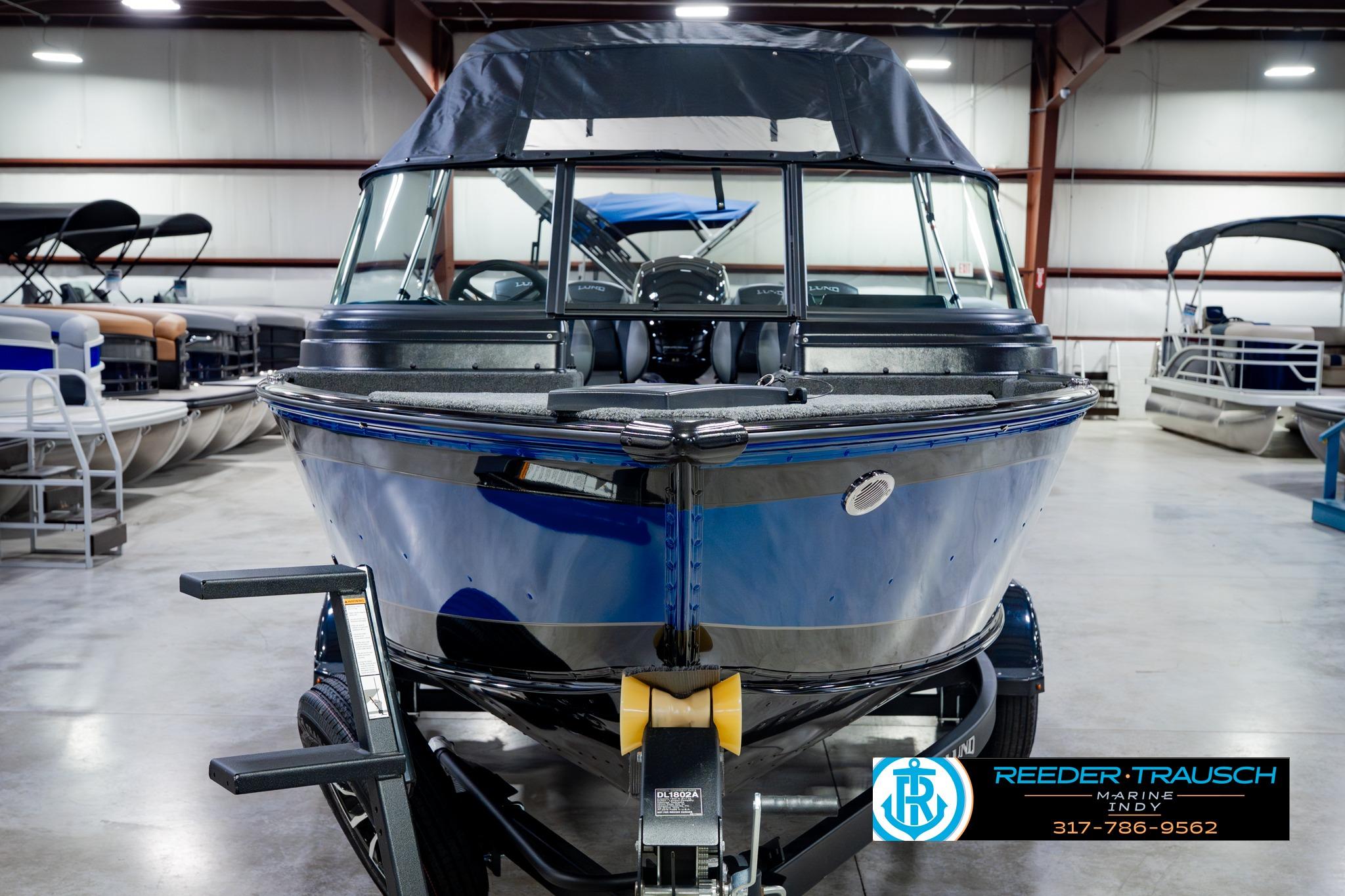 2026 Lund 1875 Impact XS boat in showroom, front view, blue exterior.