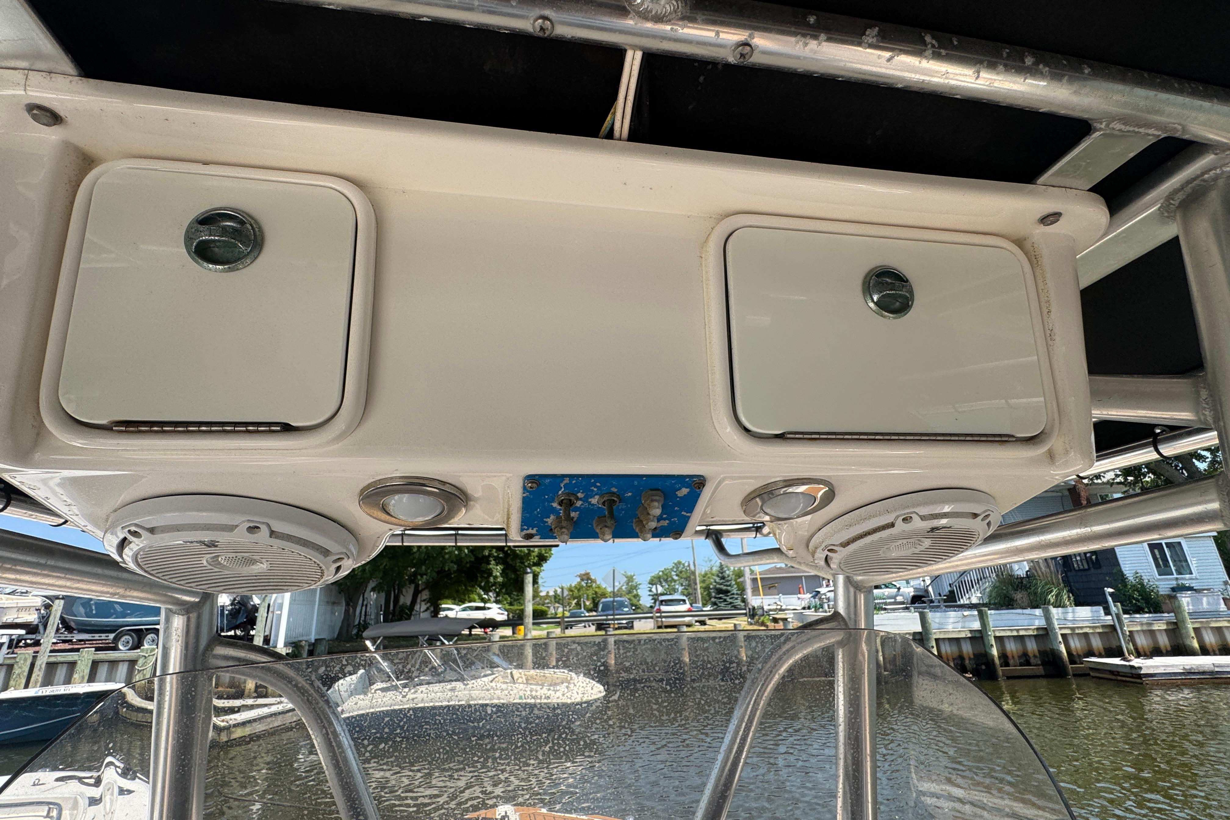 2014 Century 2301 Center Console boat with overhead storage and speakers.