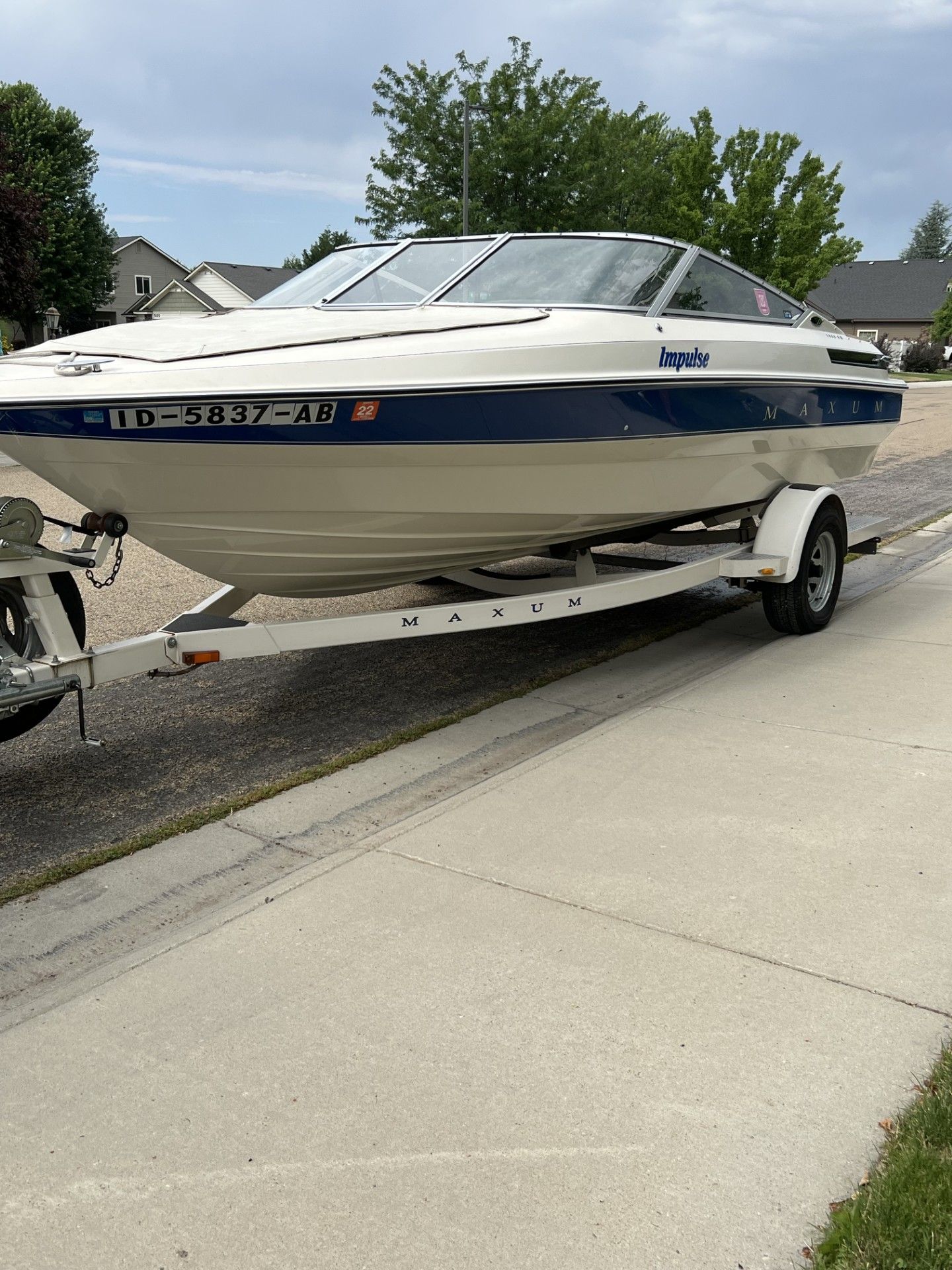 A 1991 Maxum 1800 SR boat on a trailer, parked on a street.