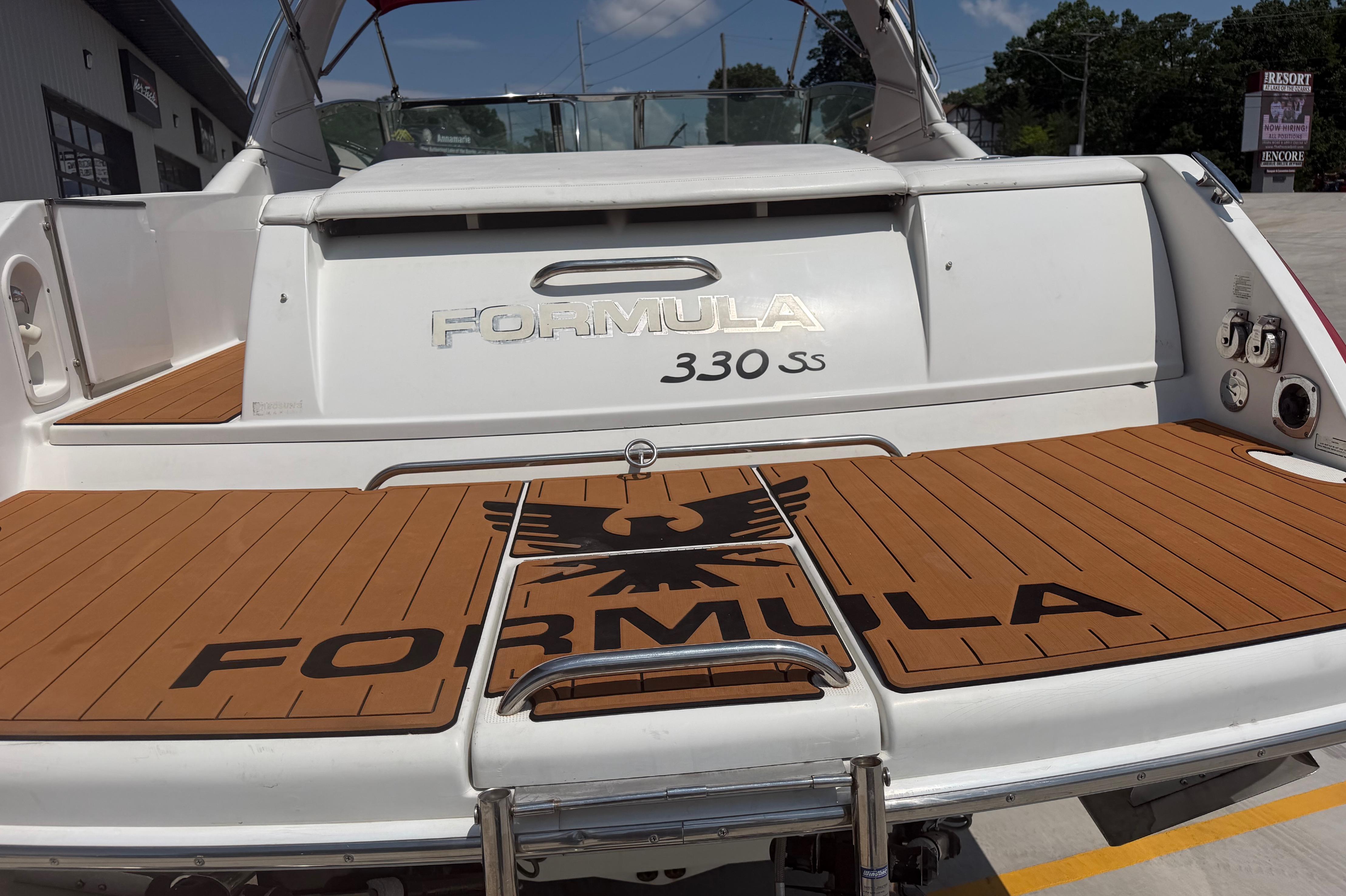 2006 Formula 330 Sun Sport boat with teak deck and logo, docked outdoors.
