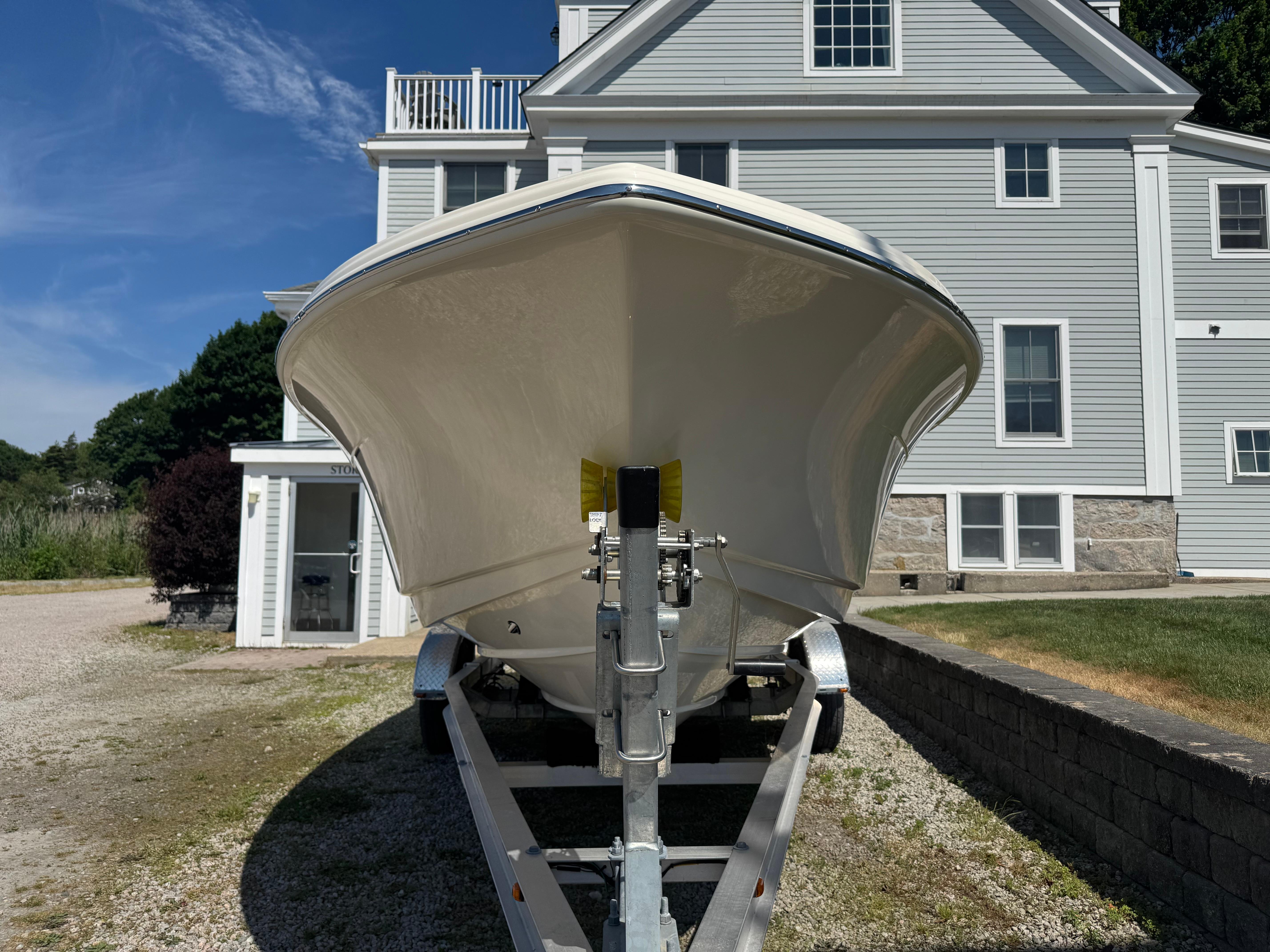 2025 Scout 215 Dorado boat on trailer, parked in front of a house.