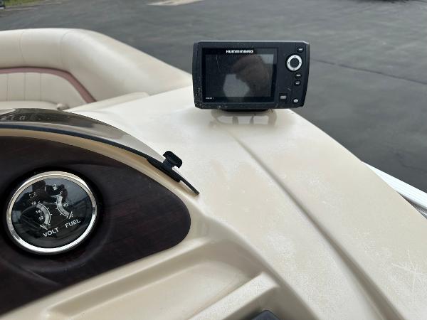 Close-up of a boat dashboard with a Humminbird fish finder and a voltmeter.