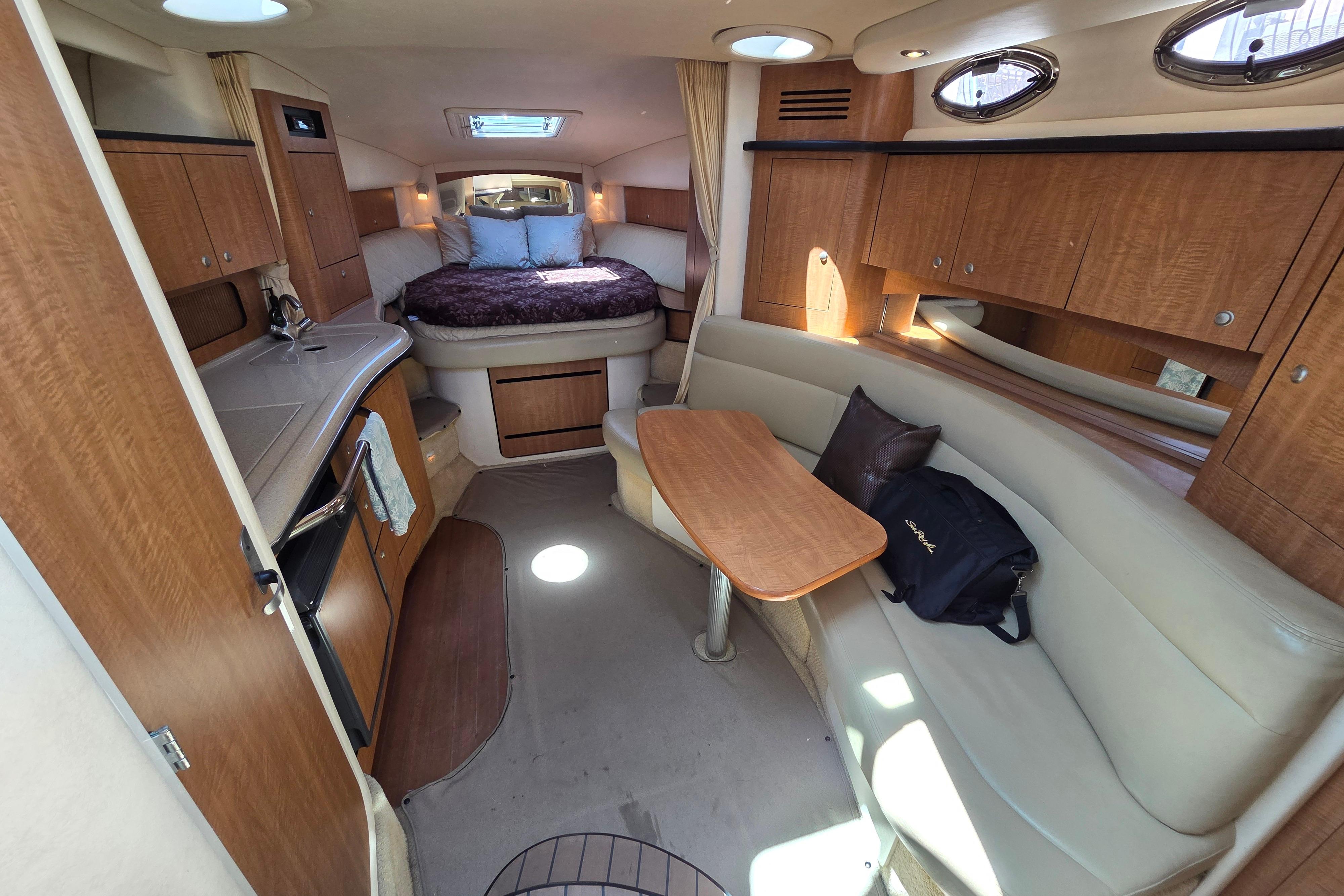Interior of 2006 Sea Ray Sundancer 320 yacht with cozy seating and elegant wood finishes.