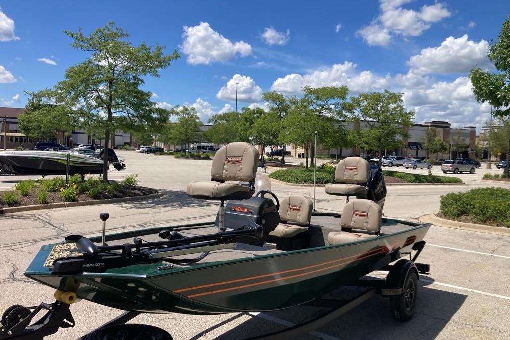 2026 Tracker Bass Tracker Classic Limited boat in parking lot under blue sky.