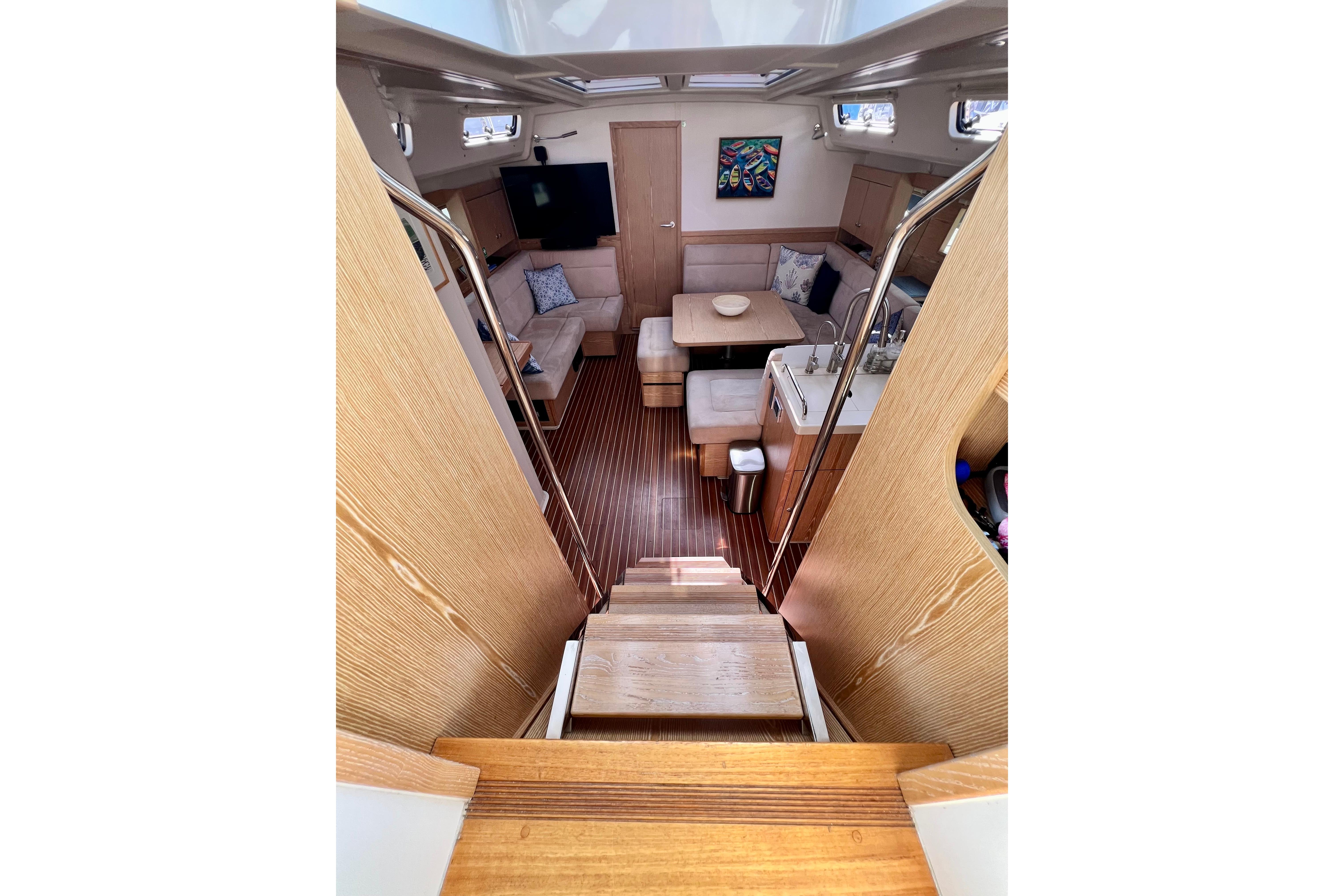 Interior of 2016 Hanse 455 yacht, featuring cozy seating, wooden flooring, and modern amenities.