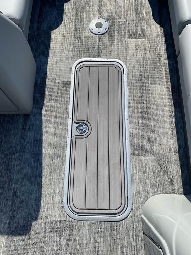2024 Ranger Reata 223C boat deck with storage hatch and gray flooring.
