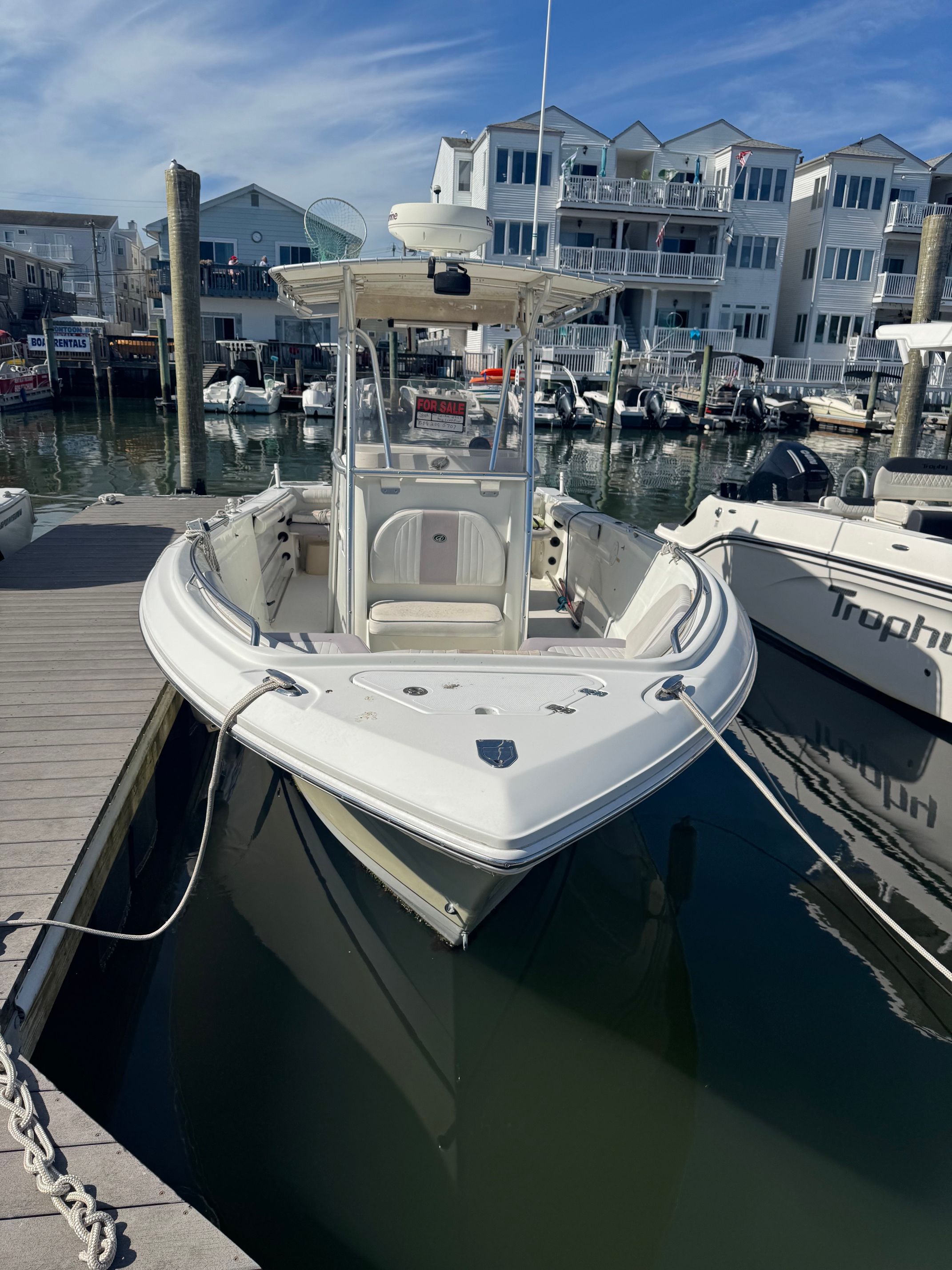 2006 Sailfish 2360 CC boat docked in marina.