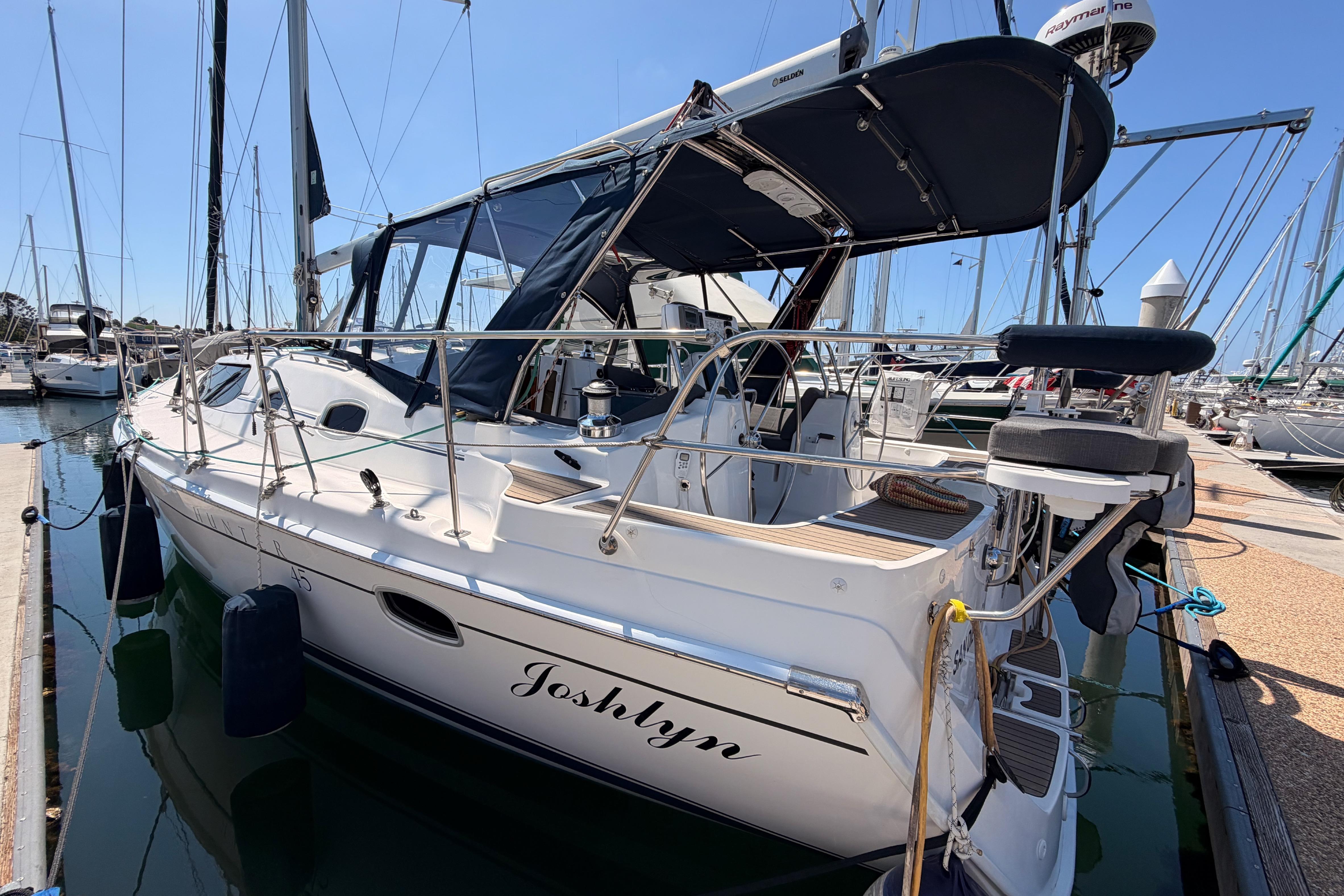 2008 Hunter 45 Deck Salon sailboat docked in marina, featuring sleek design and spacious deck.