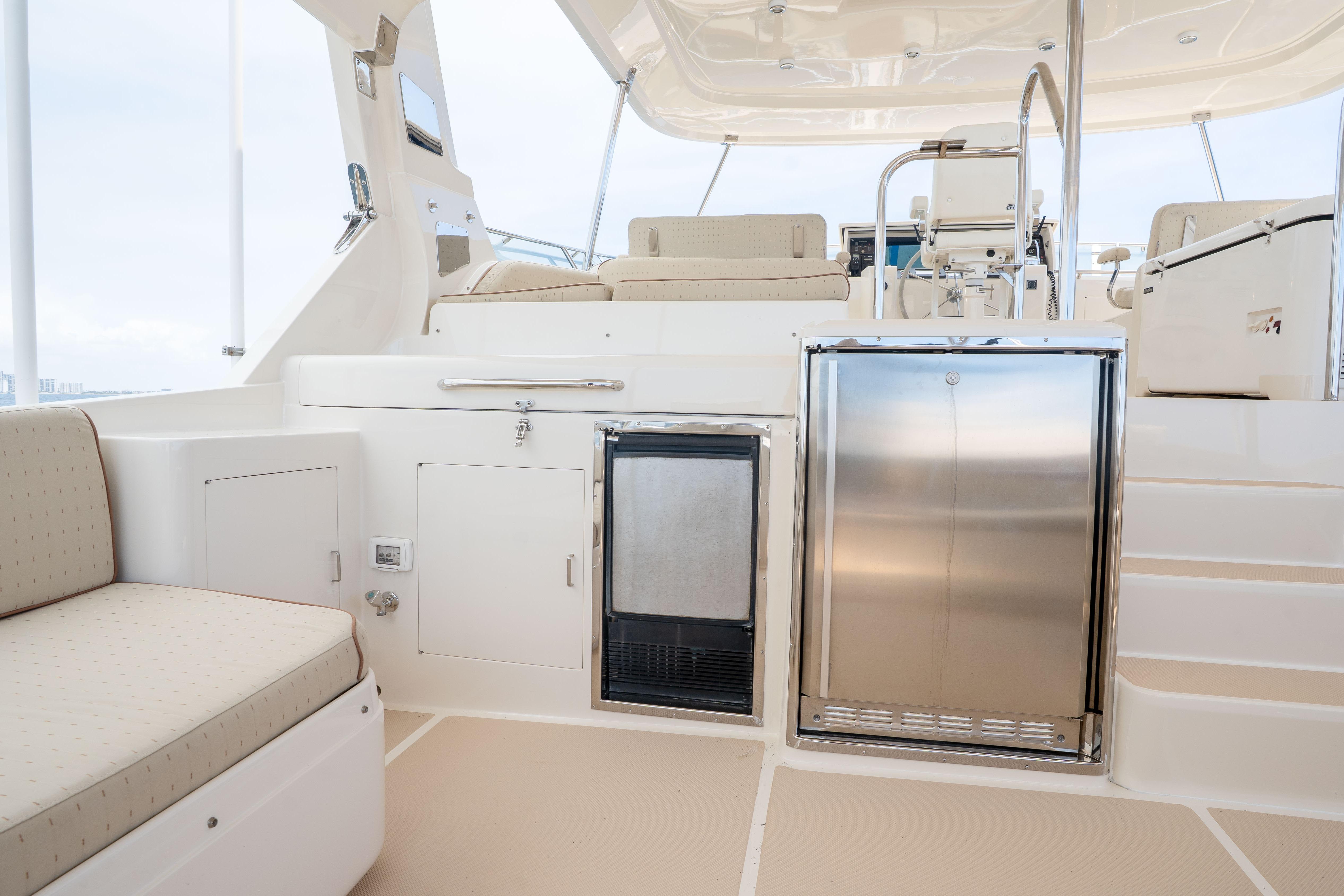 Luxurious 2006 Fleming 75 yacht interior with seating, storage, and stainless steel appliances.