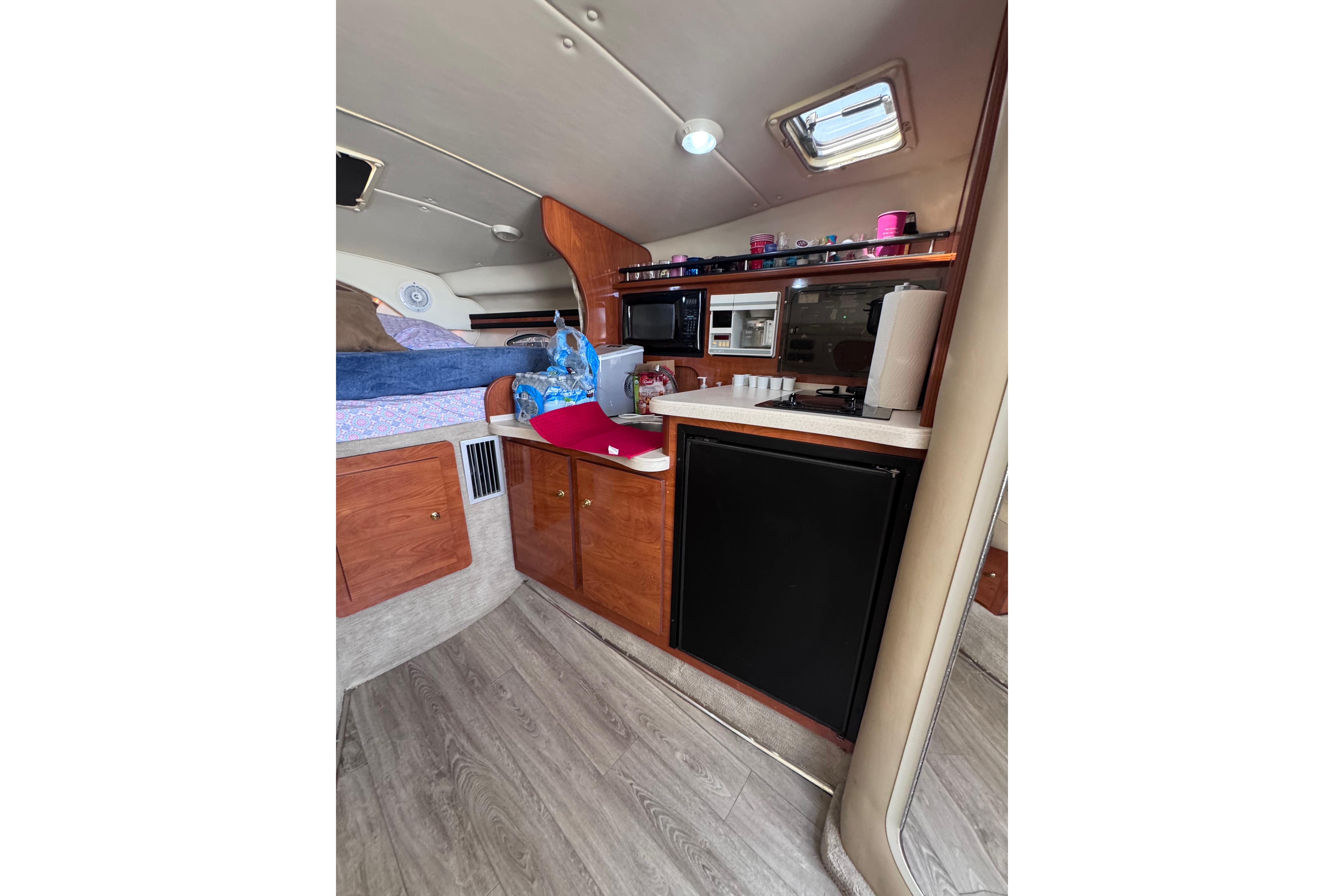 2003 Rinker Fiesta Vee 312 cabin interior with kitchenette and sleeping area.