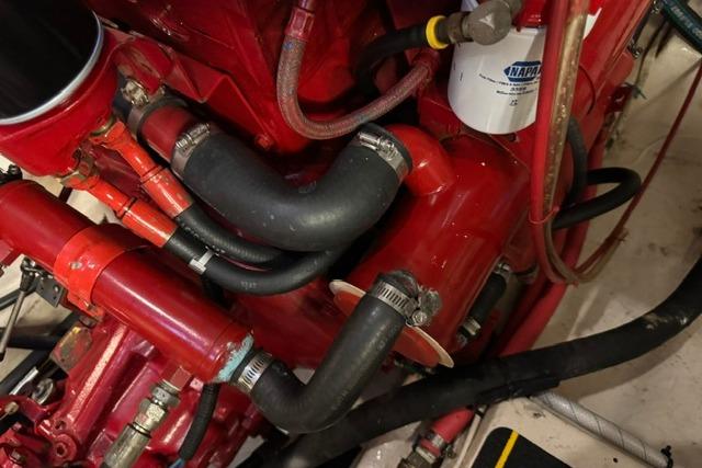 Engine components of a 1986 Kadey-Krogen 42 boat, featuring red hoses and a NAPA filter.