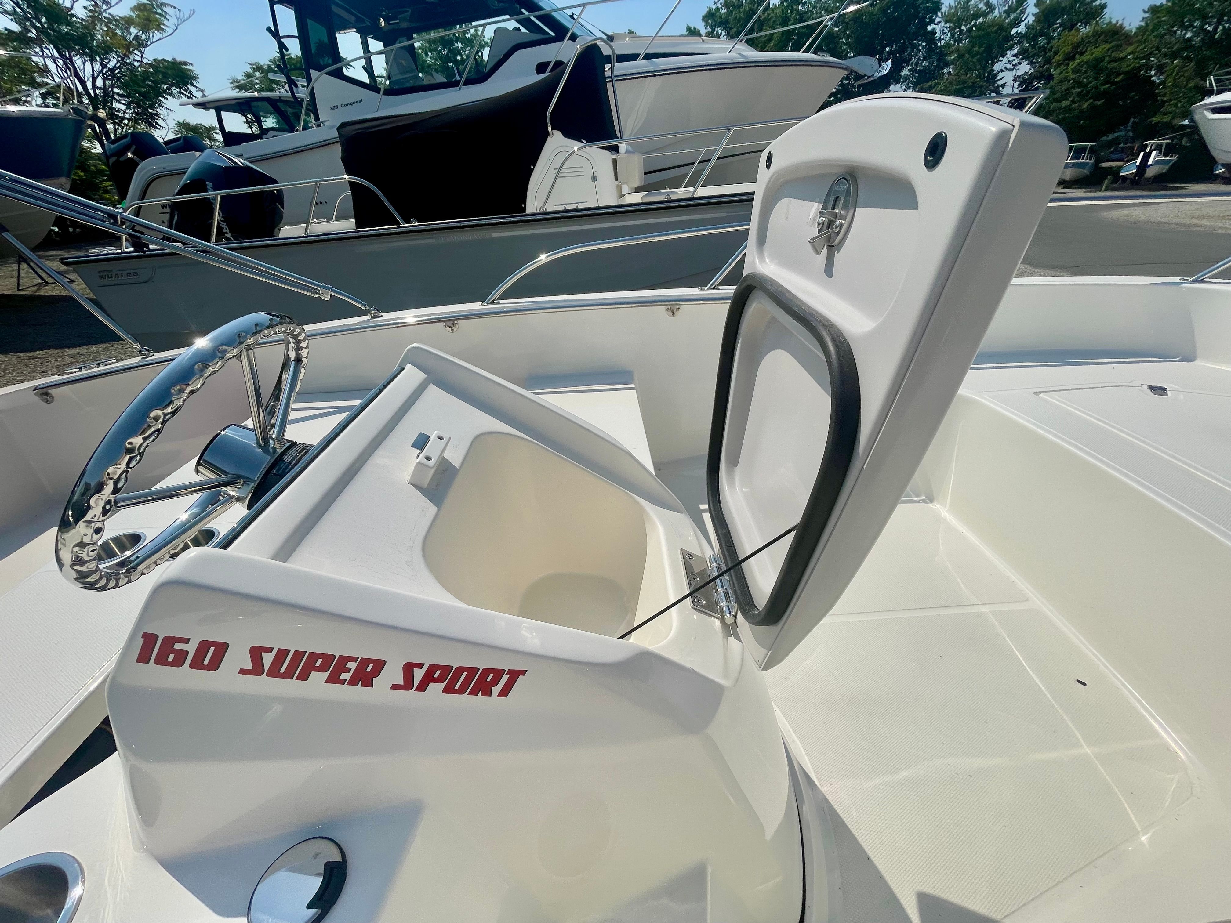 The image shows the cockpit of a Boston Whaler 160 Super Sport with open storage.
