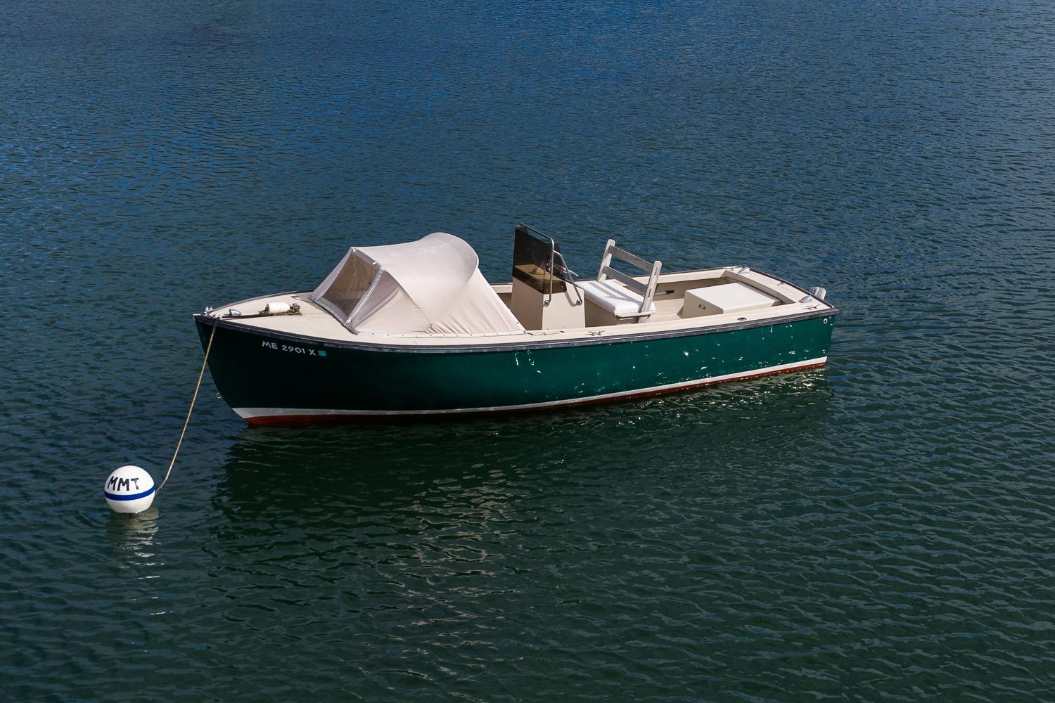 1989 Ellis 24 Open boat moored on calm water with a buoy.