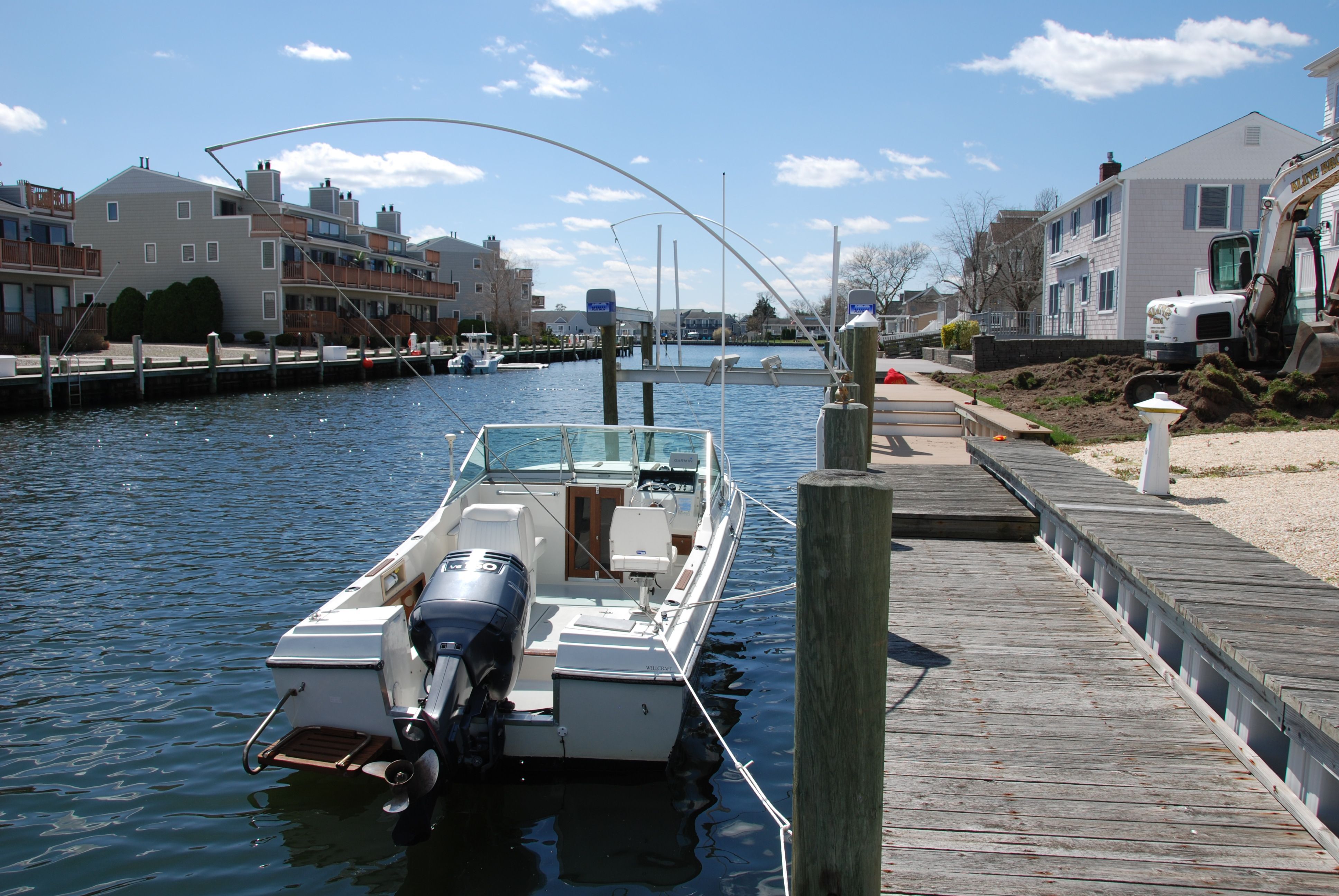 A 1987 Wellcraft V-20 Steplift is docked in a calm canal.