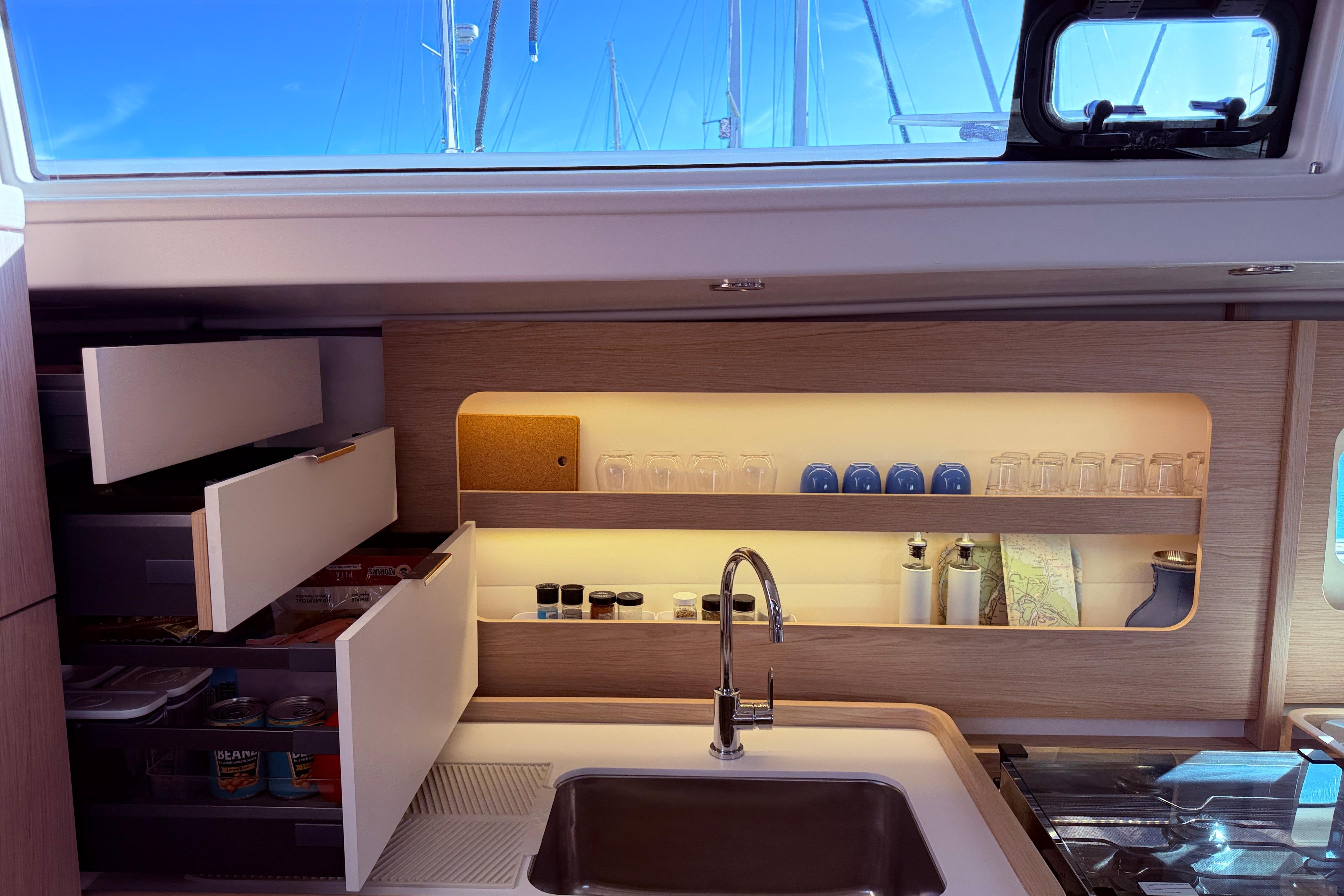Luxurious kitchen interior of 2022 Beneteau Oceanis Yacht 54 with modern cabinetry and sink.