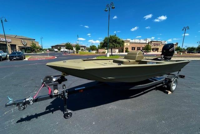 2026 Tracker Grizzly 1648 SC boat on trailer in parking lot under clear blue sky.