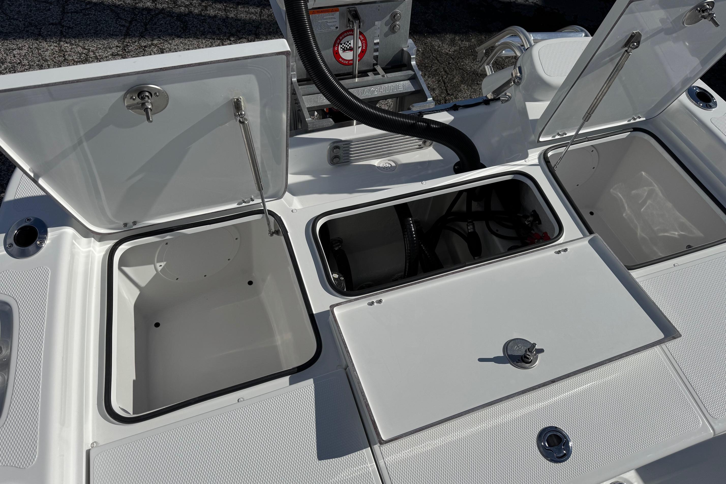 Open storage compartments on a 2026 BlackJack 256 Bay boat deck.