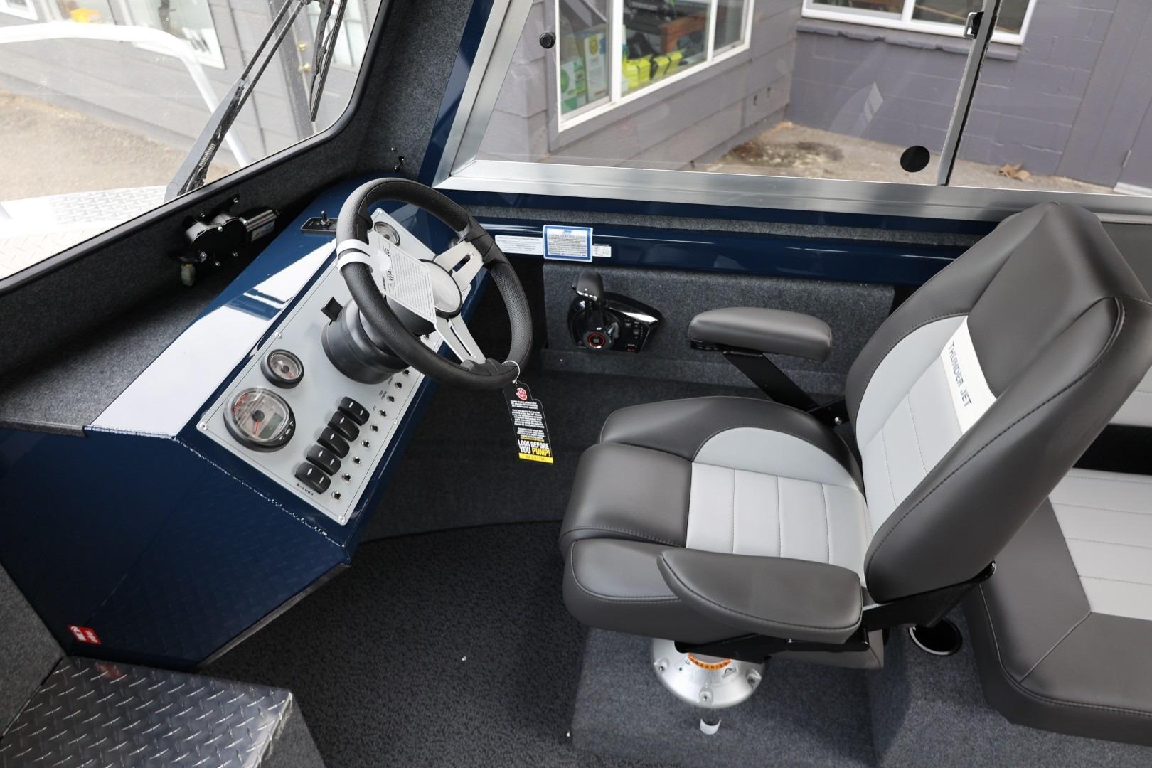 Interior of 2026 Thunder Jet 24 Alexis Pro boat, featuring steering wheel and captain's chair.