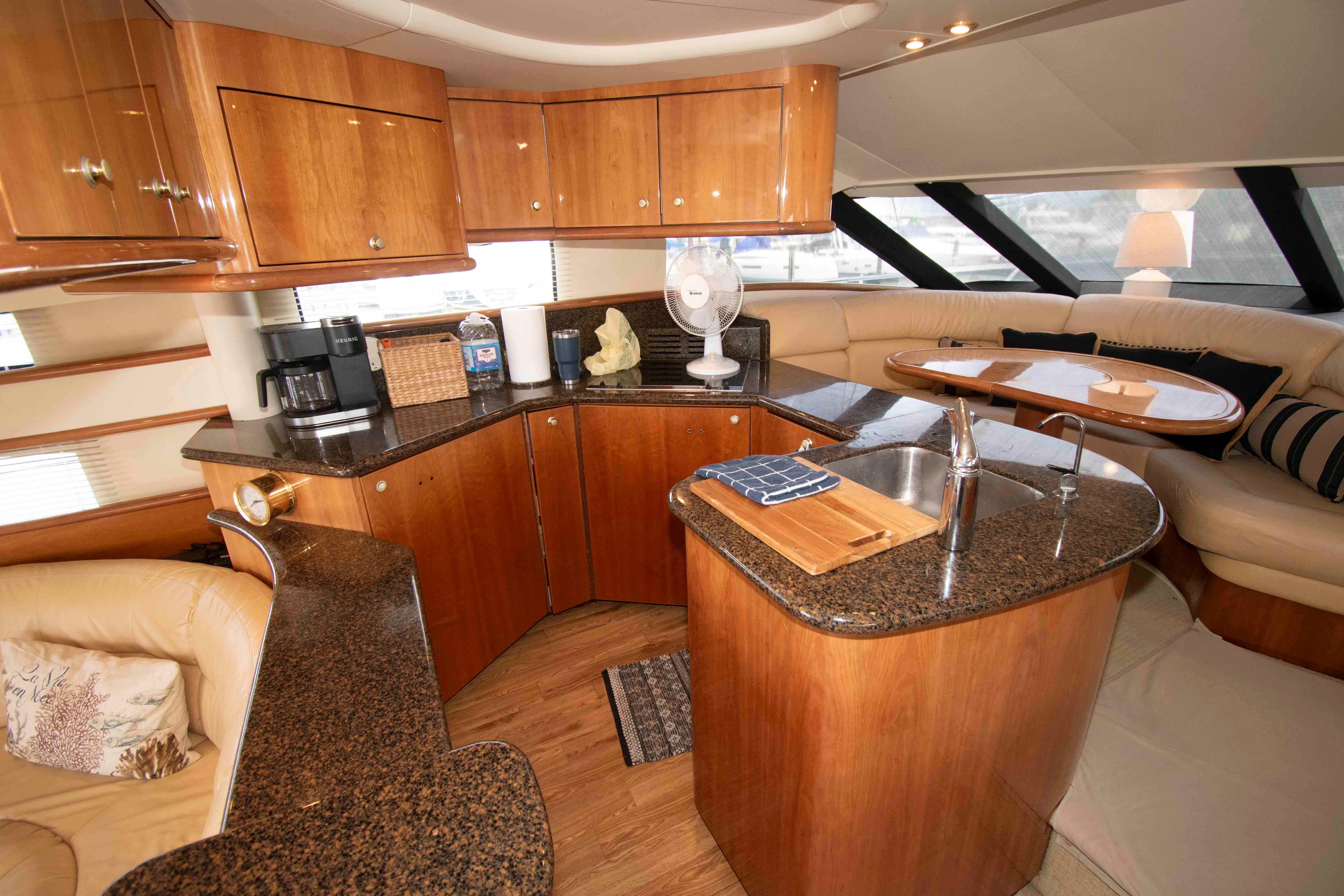 Luxurious 2003 Neptunus 56 Flybridge yacht interior with modern kitchen and seating area.