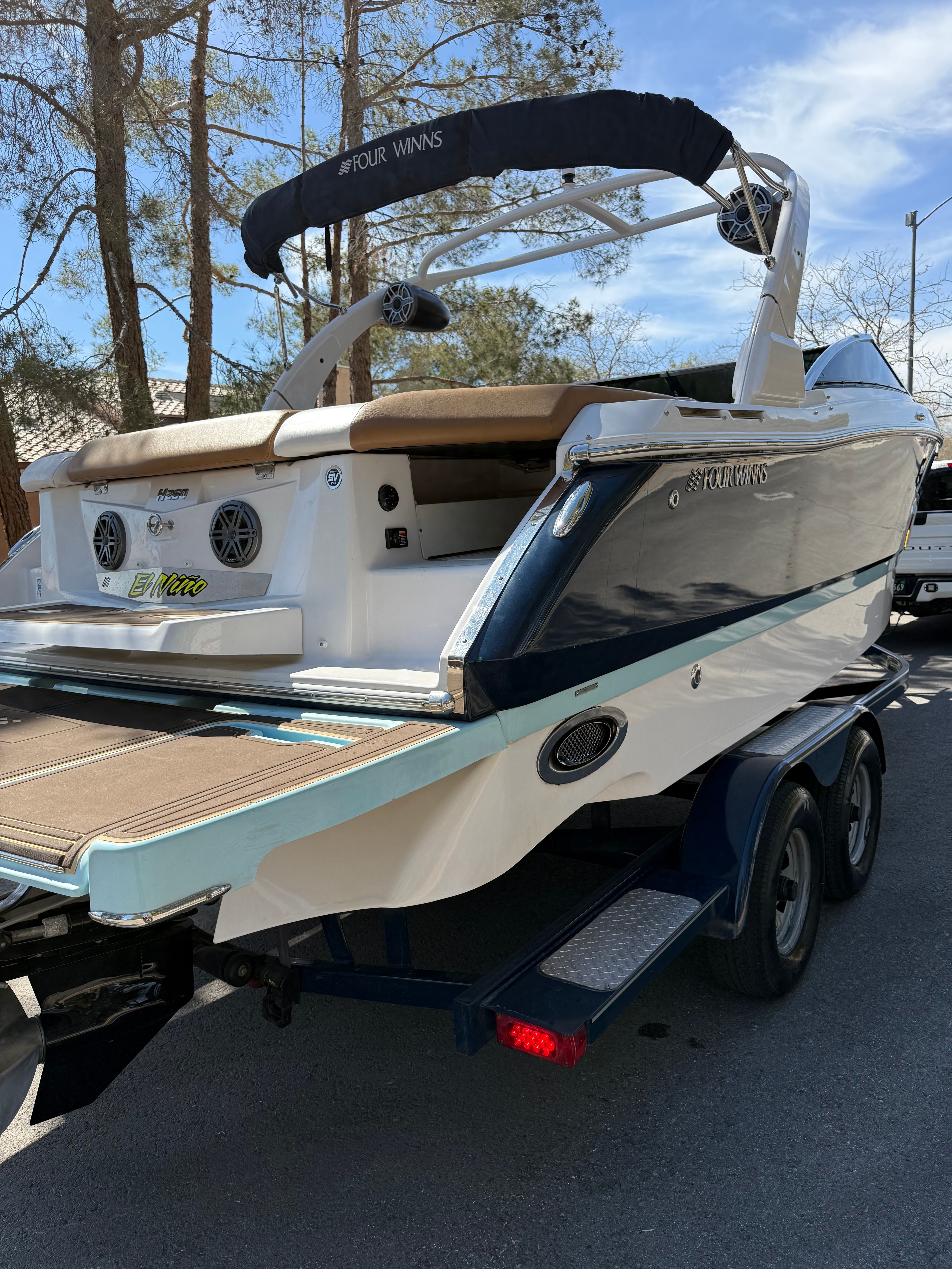 2019 Four Winns H260 boat parked on trailer outdoors.